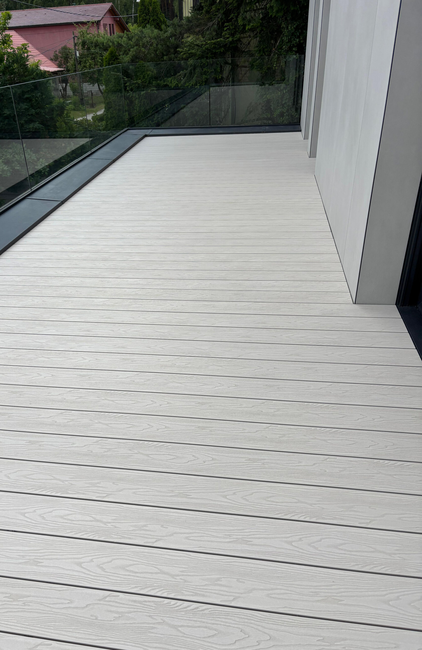 Modern balcony finished with Bruggan Elegant Cream Latte light composite decking and glass railing