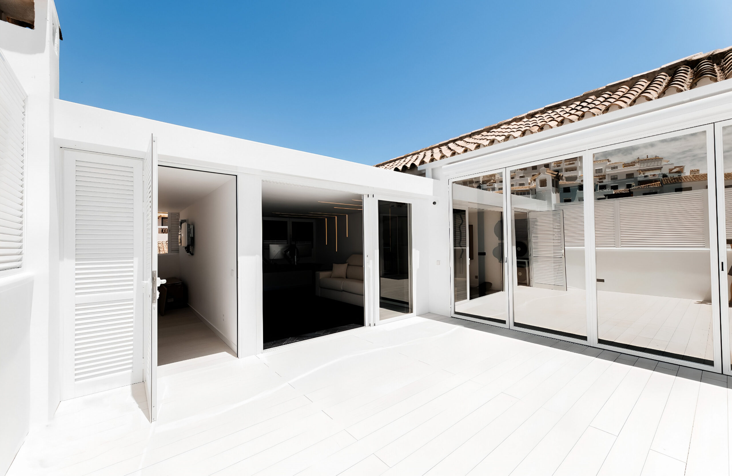 Modern white patio with Bruggan Elegant Cream Latte decking and large glass doors