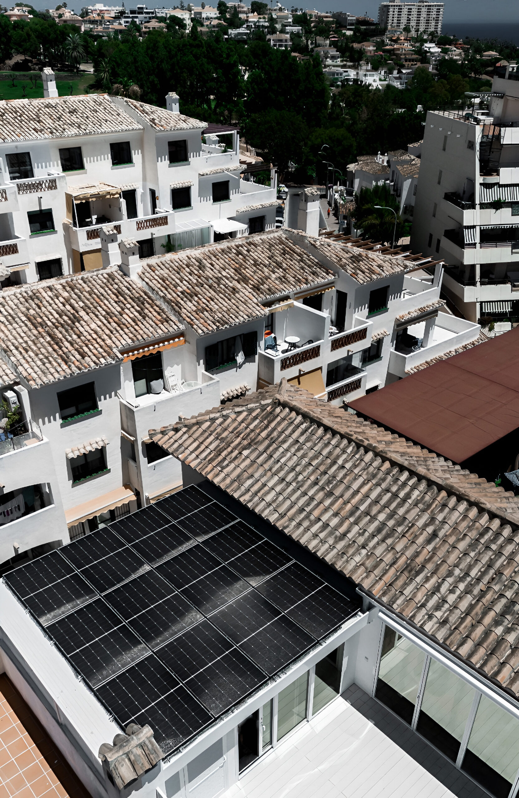 Rooftop terrace with light composite decking overlooking a Mediterranean residential area