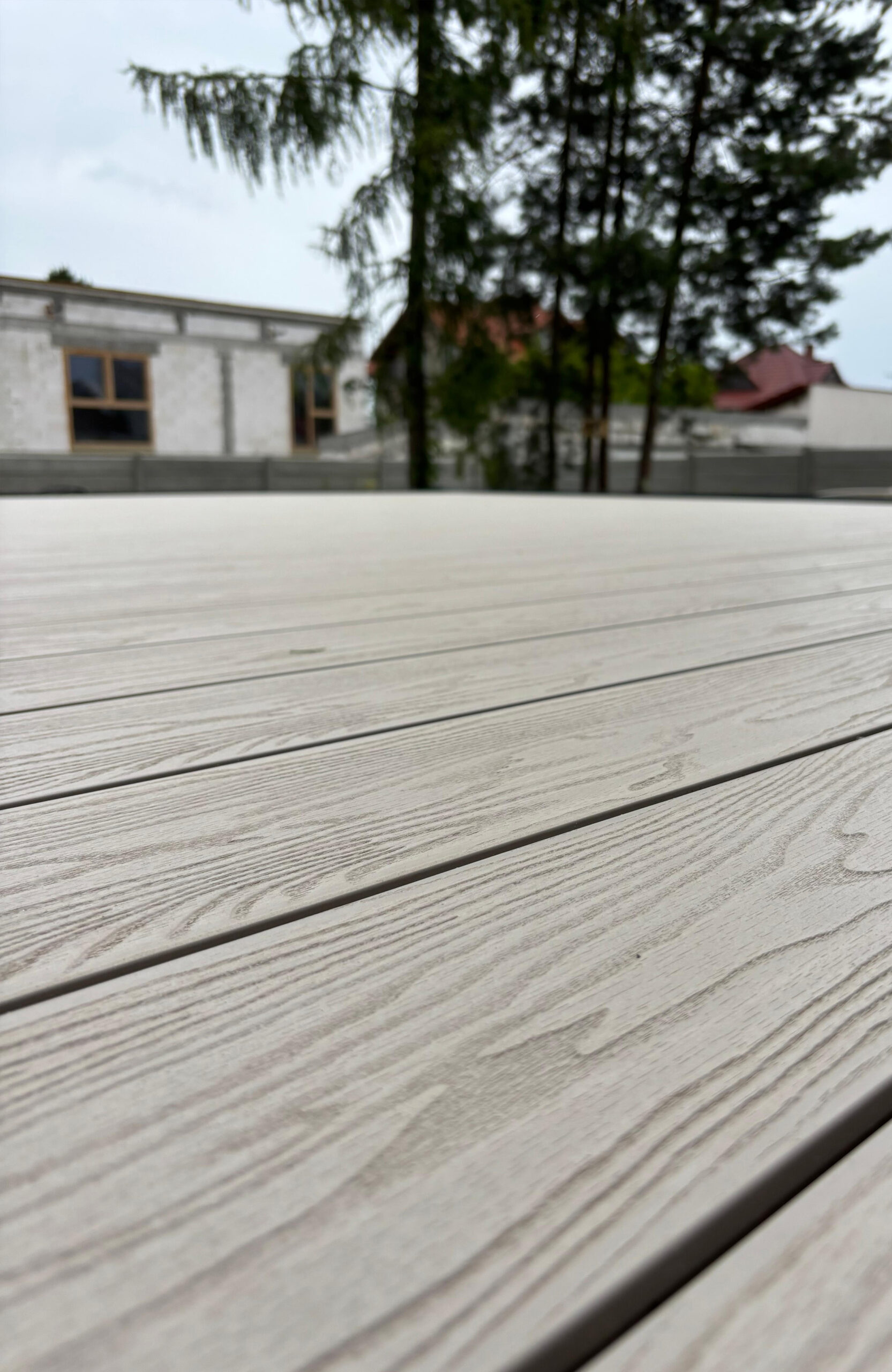 Cream Latte composite decking with natural wood grain texture on a spacious outdoor terrace