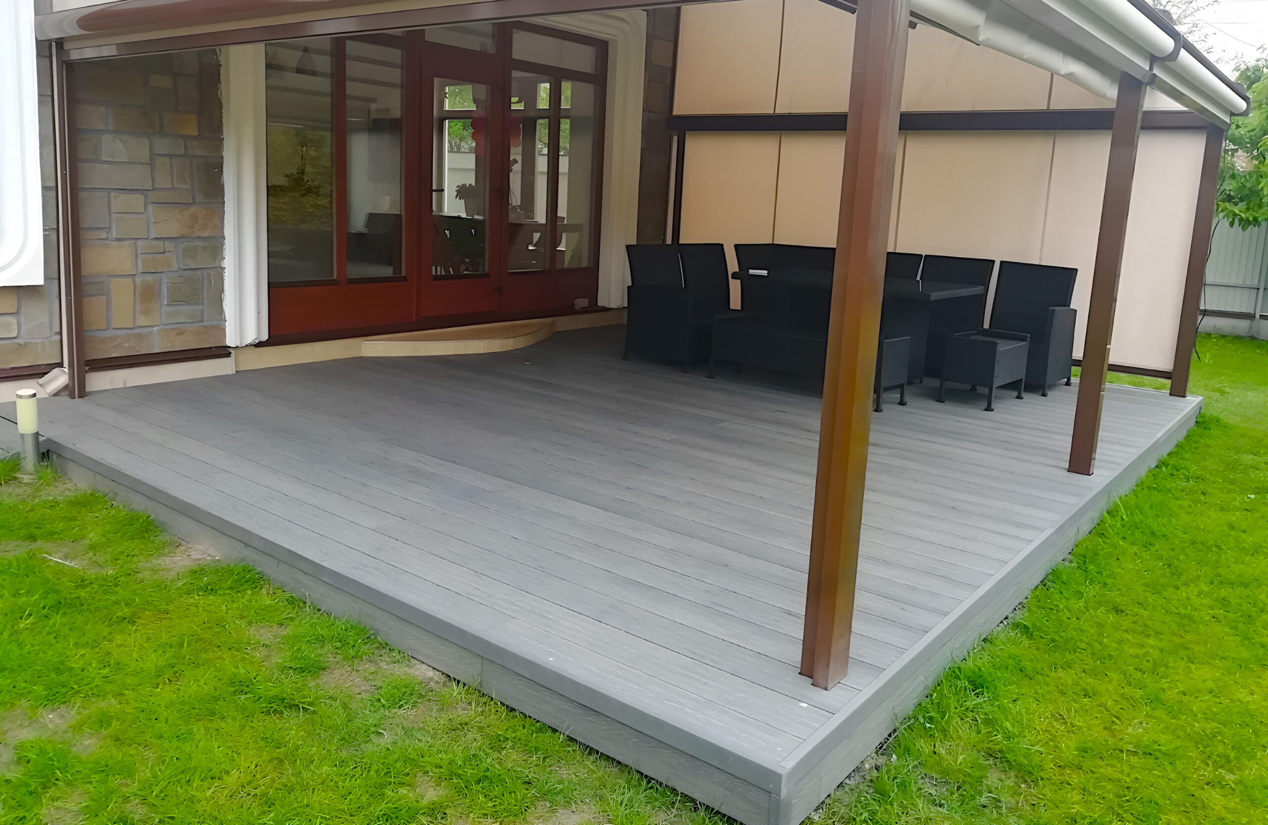 Covered patio with Bruggan Elegant Graphite composite decking and outdoor dining area