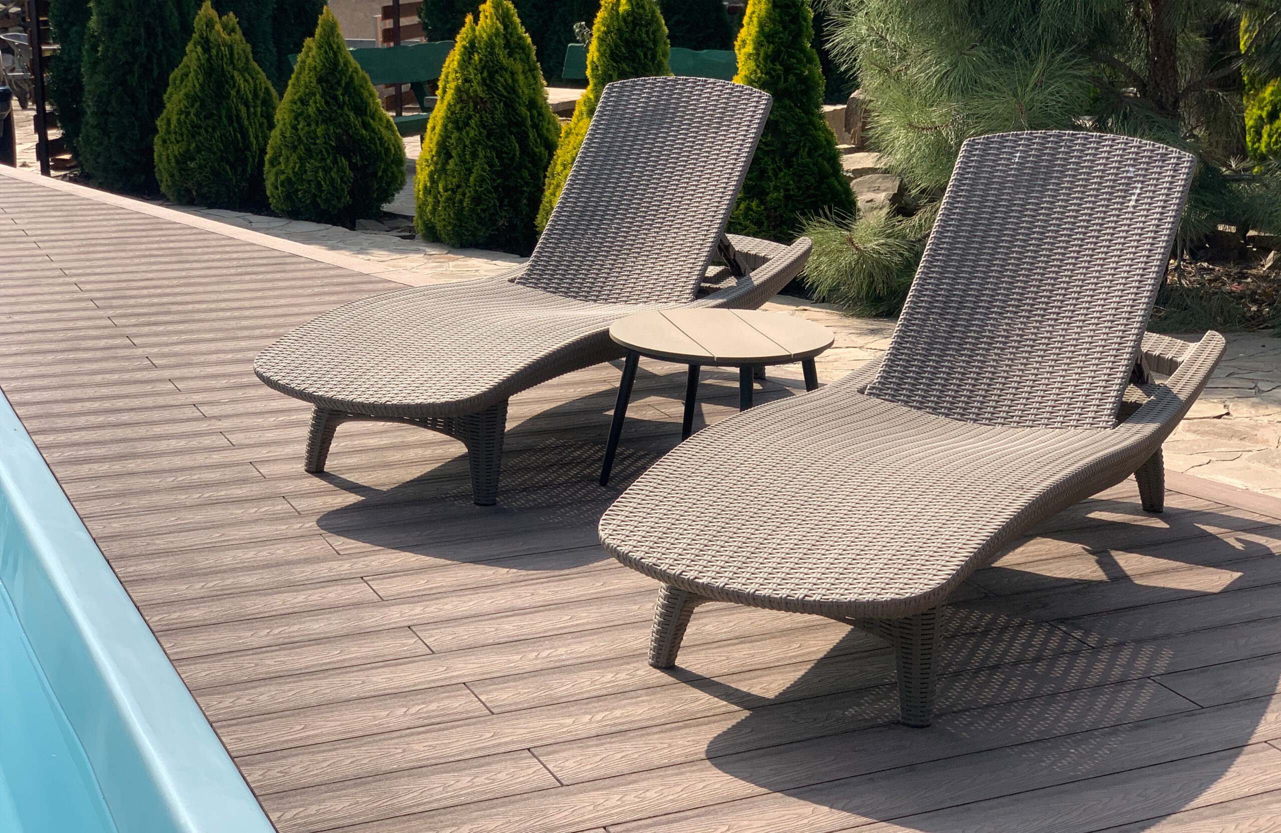 Bruggan Elegant Wine Brown composite decking with sun loungers beside an outdoor swimming pool