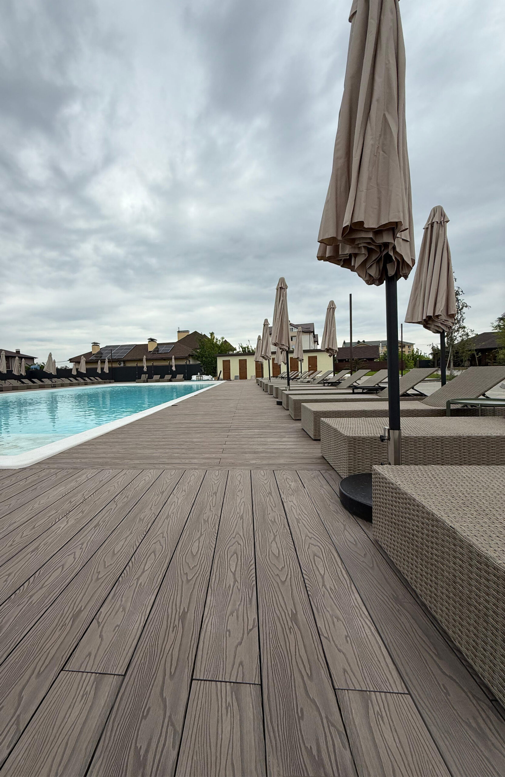 Poolside terrace with Bruggan Elegant Wine Brown decking and sun loungers at Bilohorodski Lazni, Ukraine