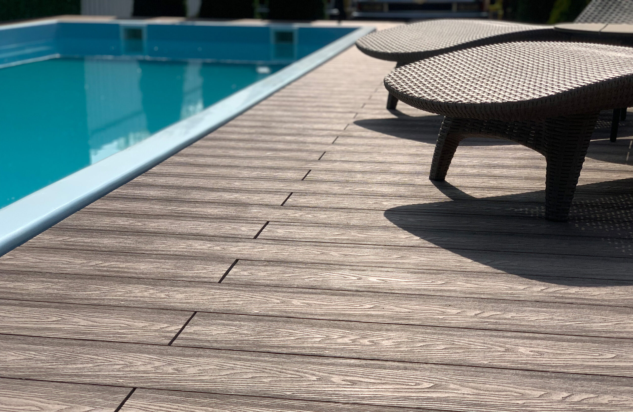 Poolside Bruggan Elegant Wine Brown decking with natural wood grain and lounge chairs