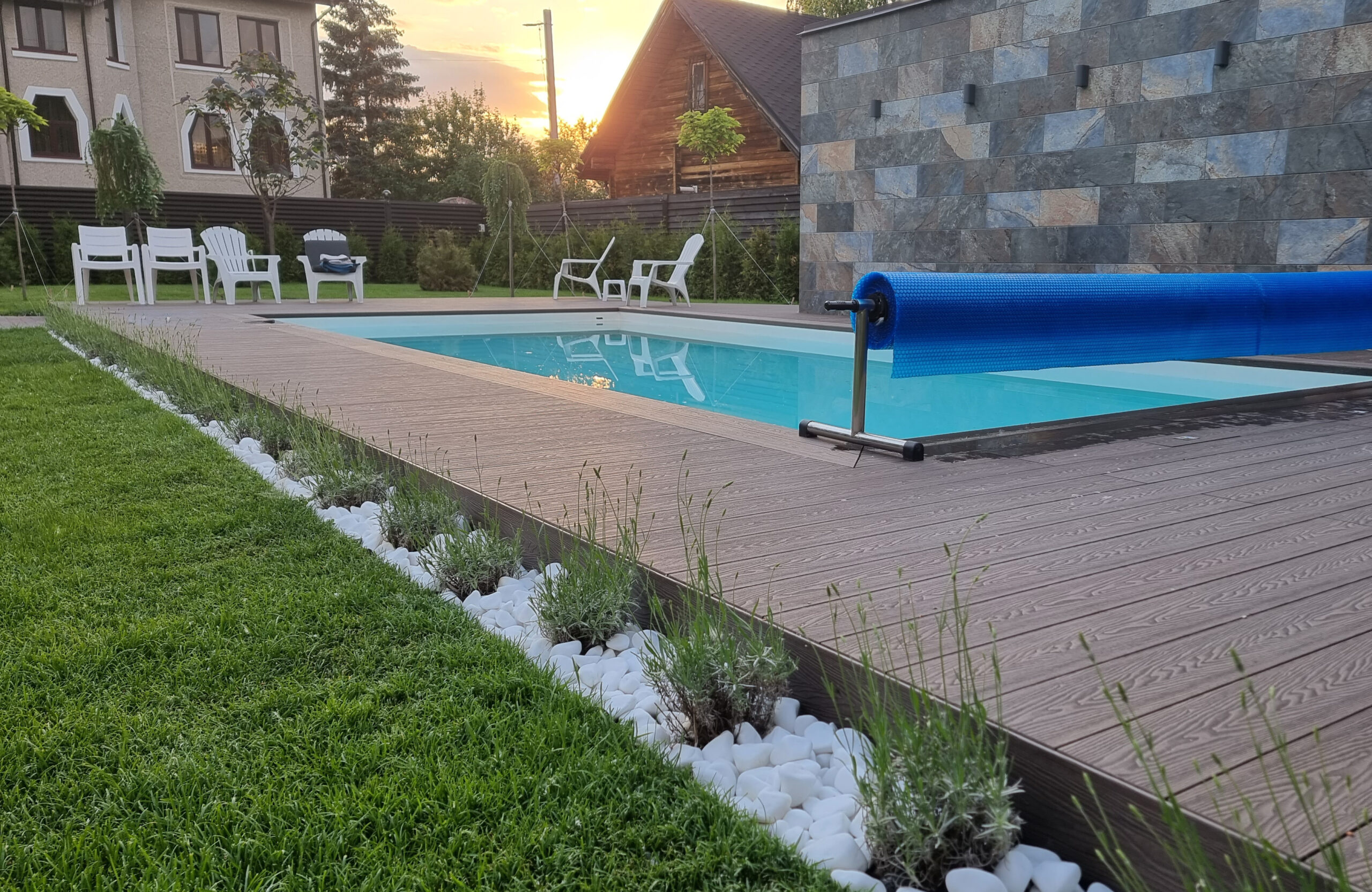 Bruggan Elegant Wine Brown composite decking around a private outdoor swimming pool with landscaped garden