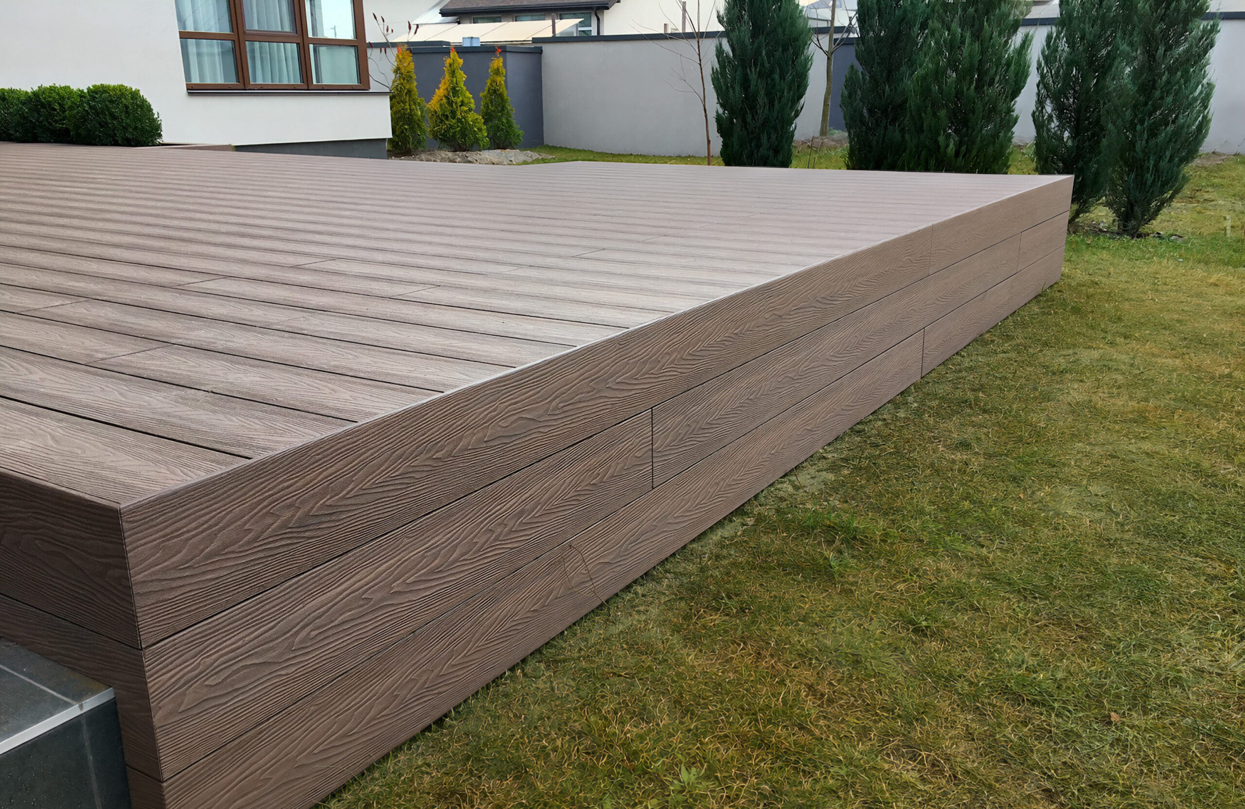 Raised terrace finished with Bruggan Elegant Wine Brown composite decking and vertical fascia boards