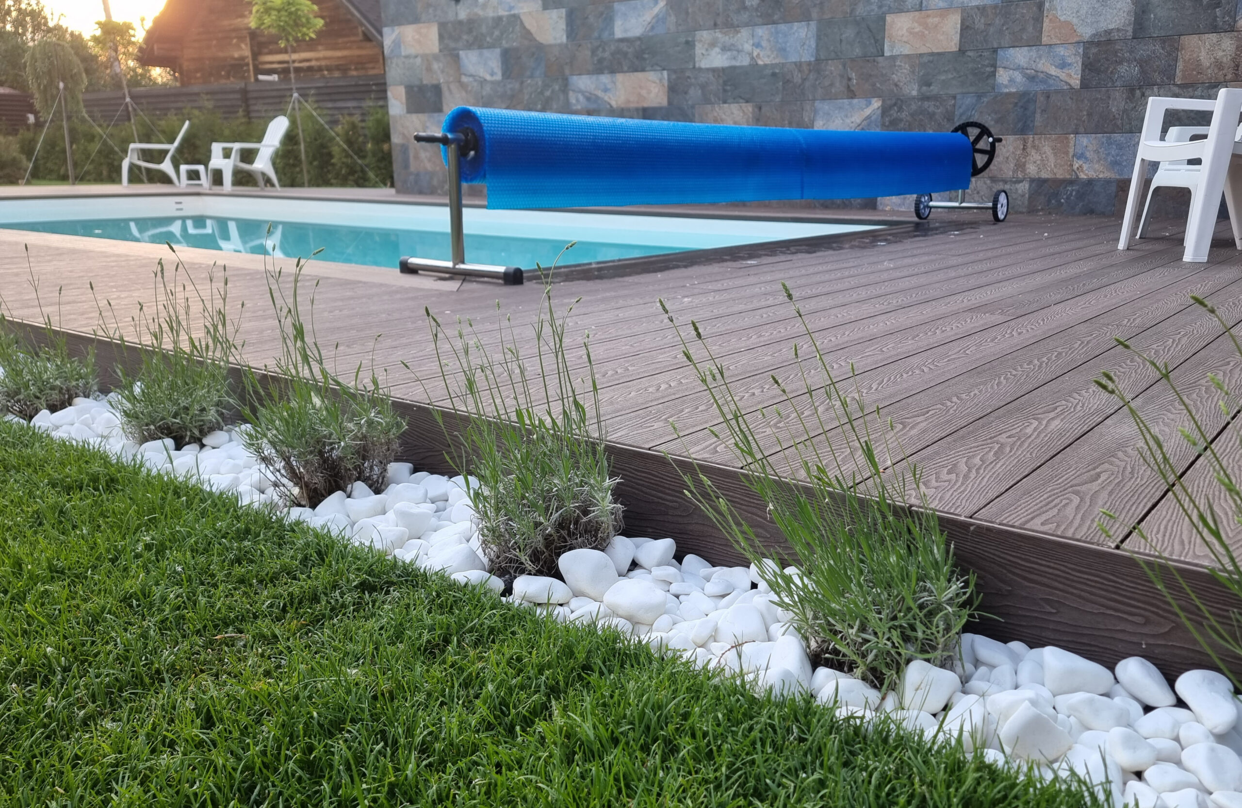 Bruggan Elegant Wine Brown composite decking around a private outdoor swimming pool with landscaped garden