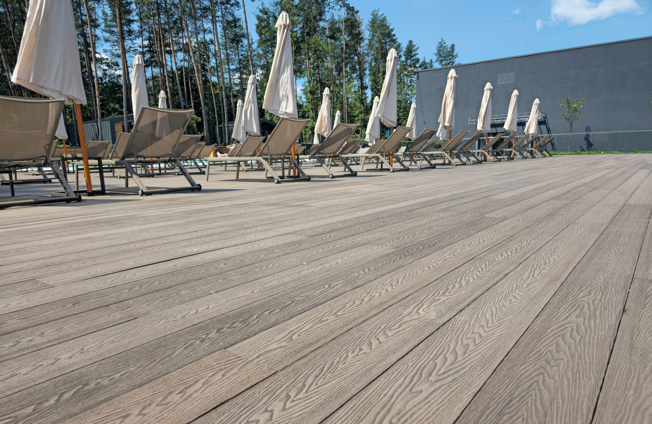 Spacious poolside terrace finished with Bruggan Elegant Wine Brown composite decking at Riverwood Relax Park, Ukraine