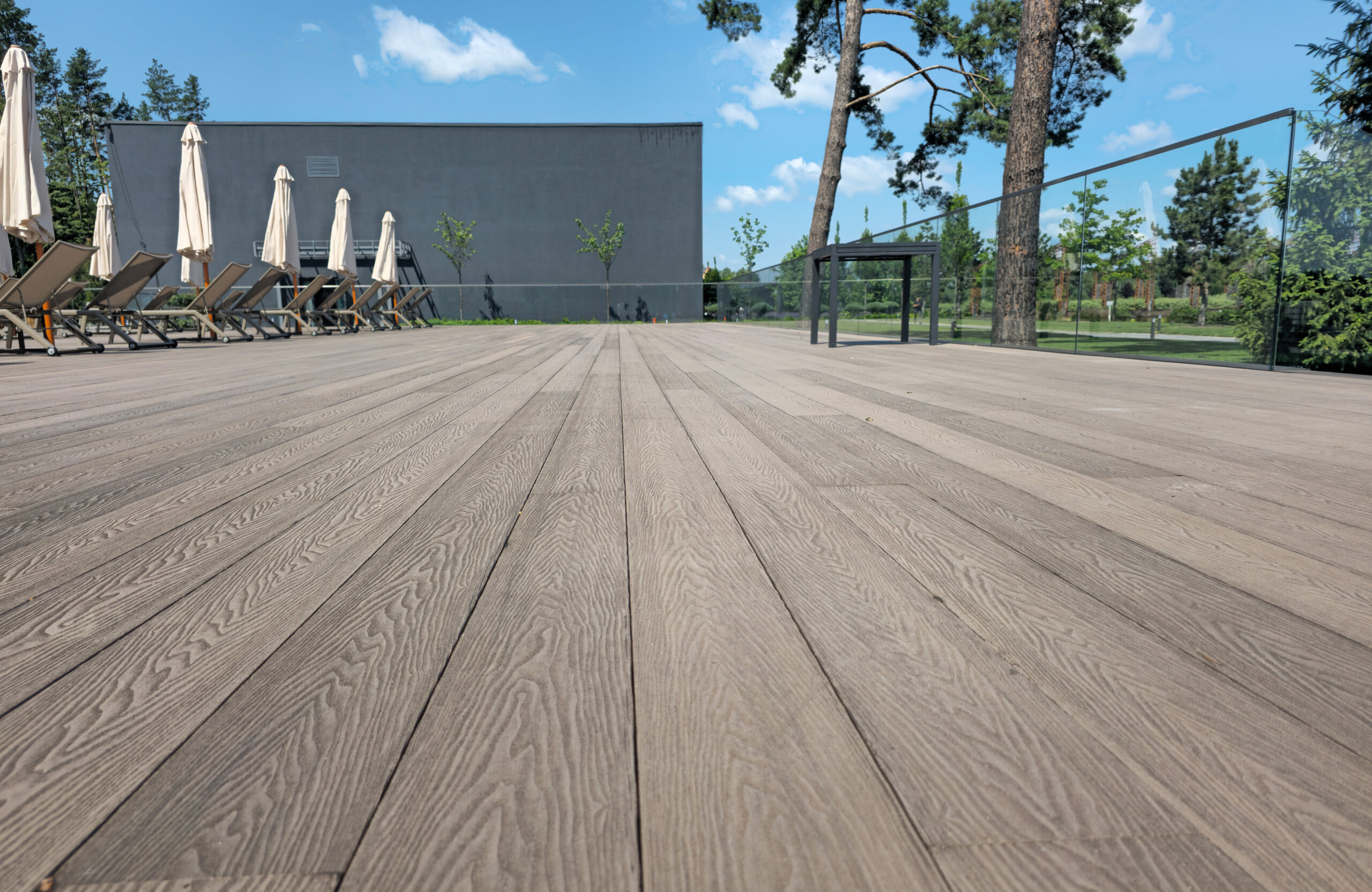 Close-up view of Bruggan Elegant Wine Brown composite decking on the pool terrace at Riverwood Relax Park, Cherkasy Oblast