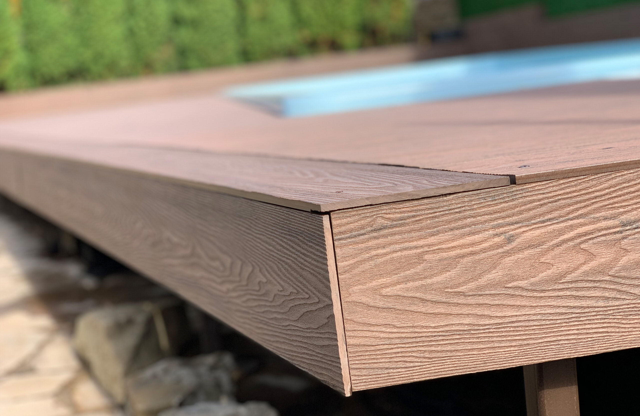 Close-up of Bruggan Elegant Wine Brown terrace edge with matching composite fascia and natural wood grain texture