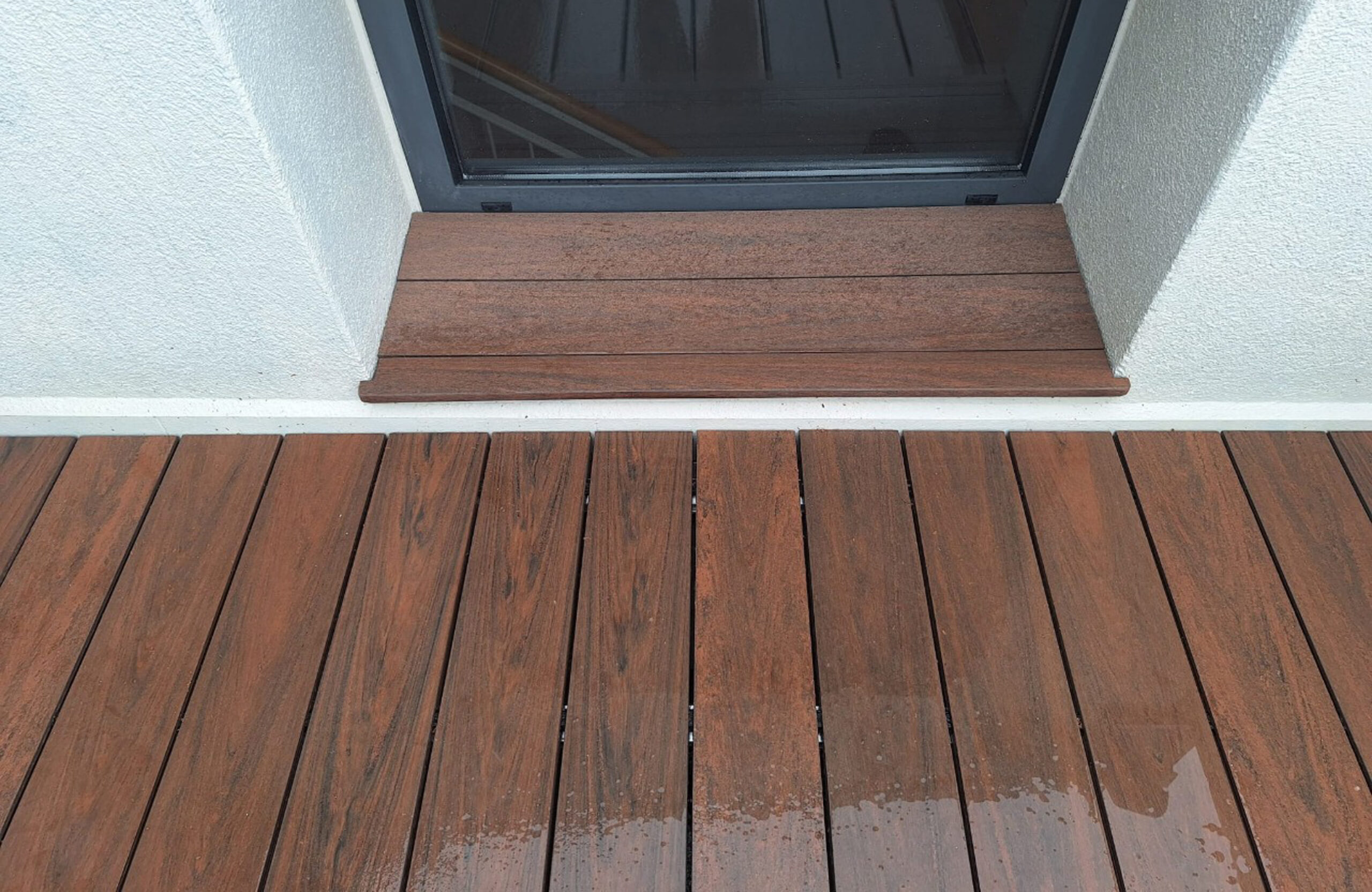Close-up of Bruggan Multicolor Cedar composite decking and matching window sill on a rooftop terrace
