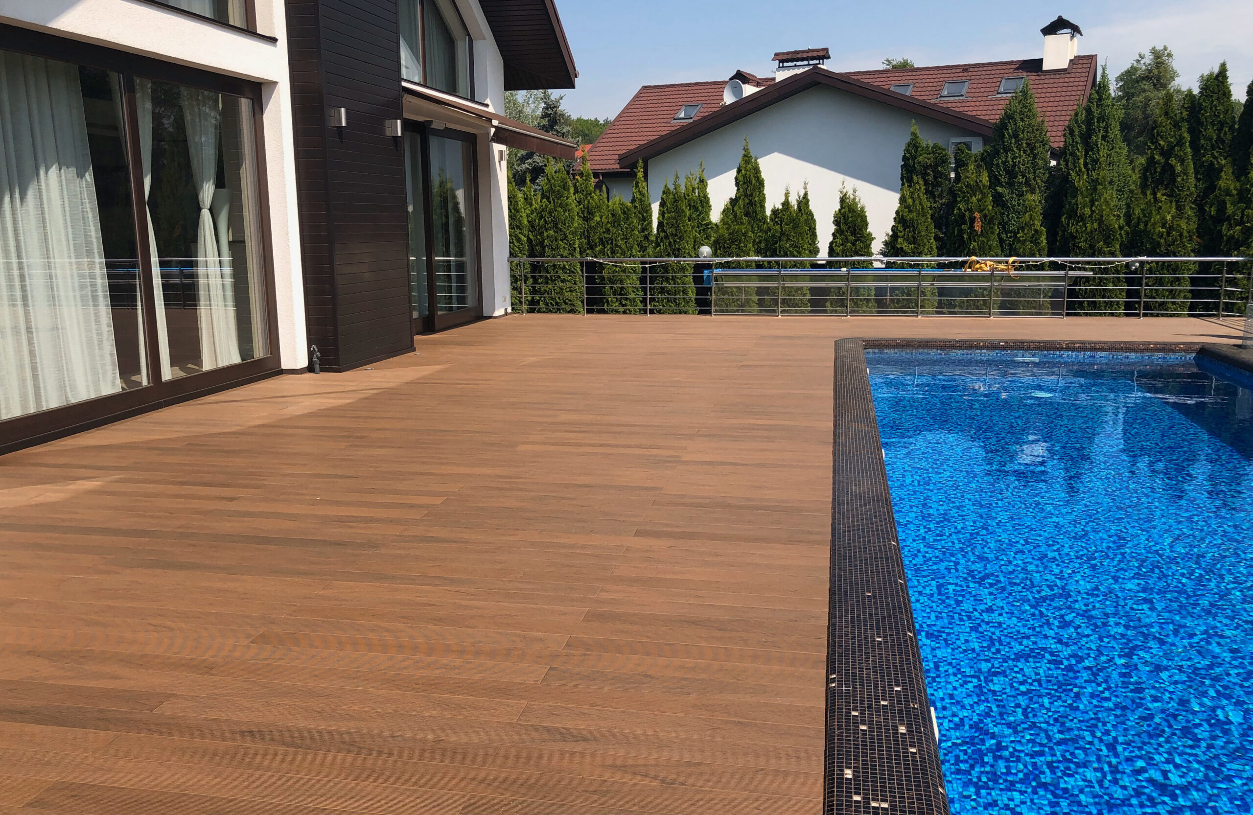 Bruggan Multicolor Cedar composite decking around a private outdoor swimming pool