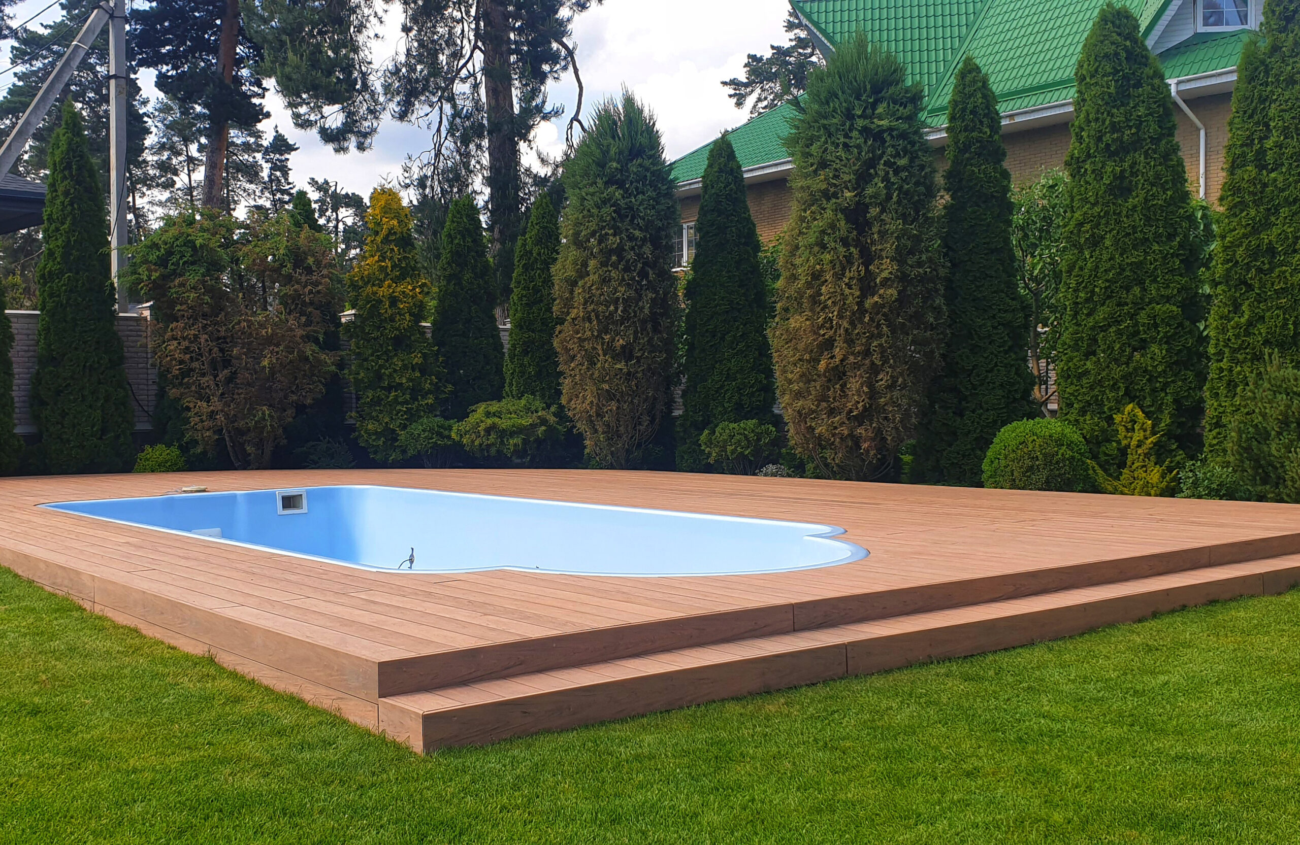 Bruggan Multicolor Cedar composite decking around a backyard swimming pool