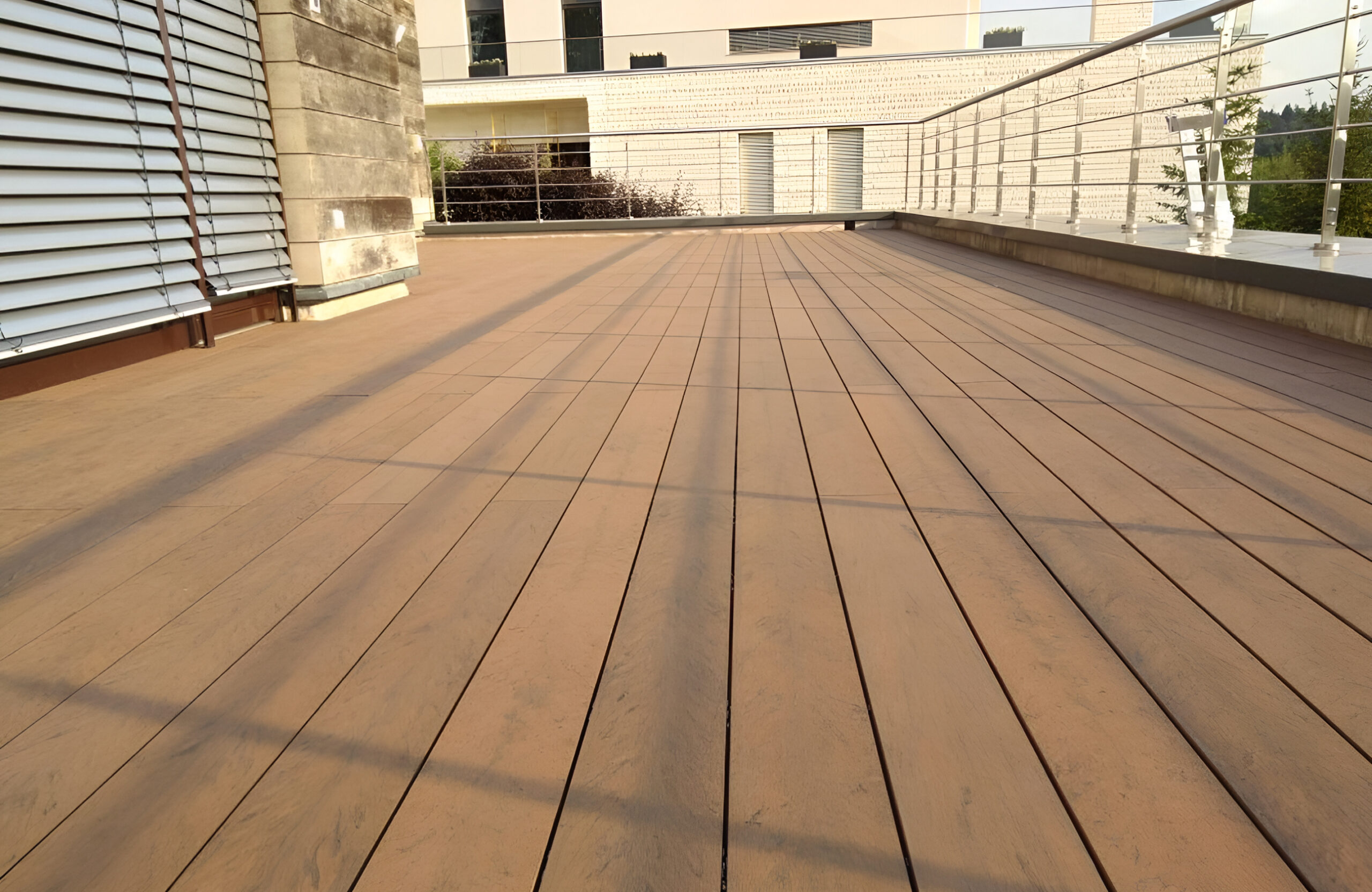 Bruggan Multicolor Cedar composite decking on a modern terrace with stainless steel railing