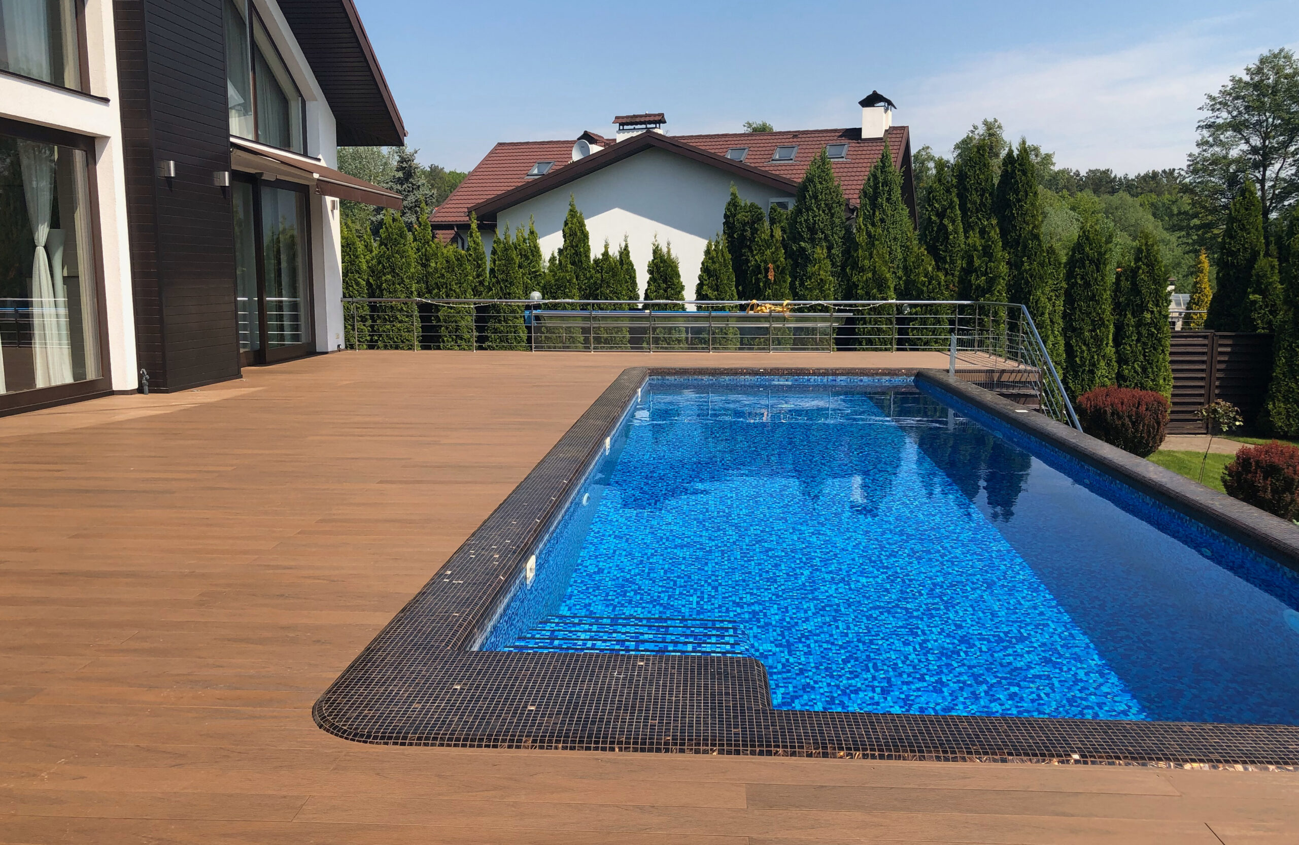 Bruggan Multicolor Cedar composite decking around a private outdoor swimming pool