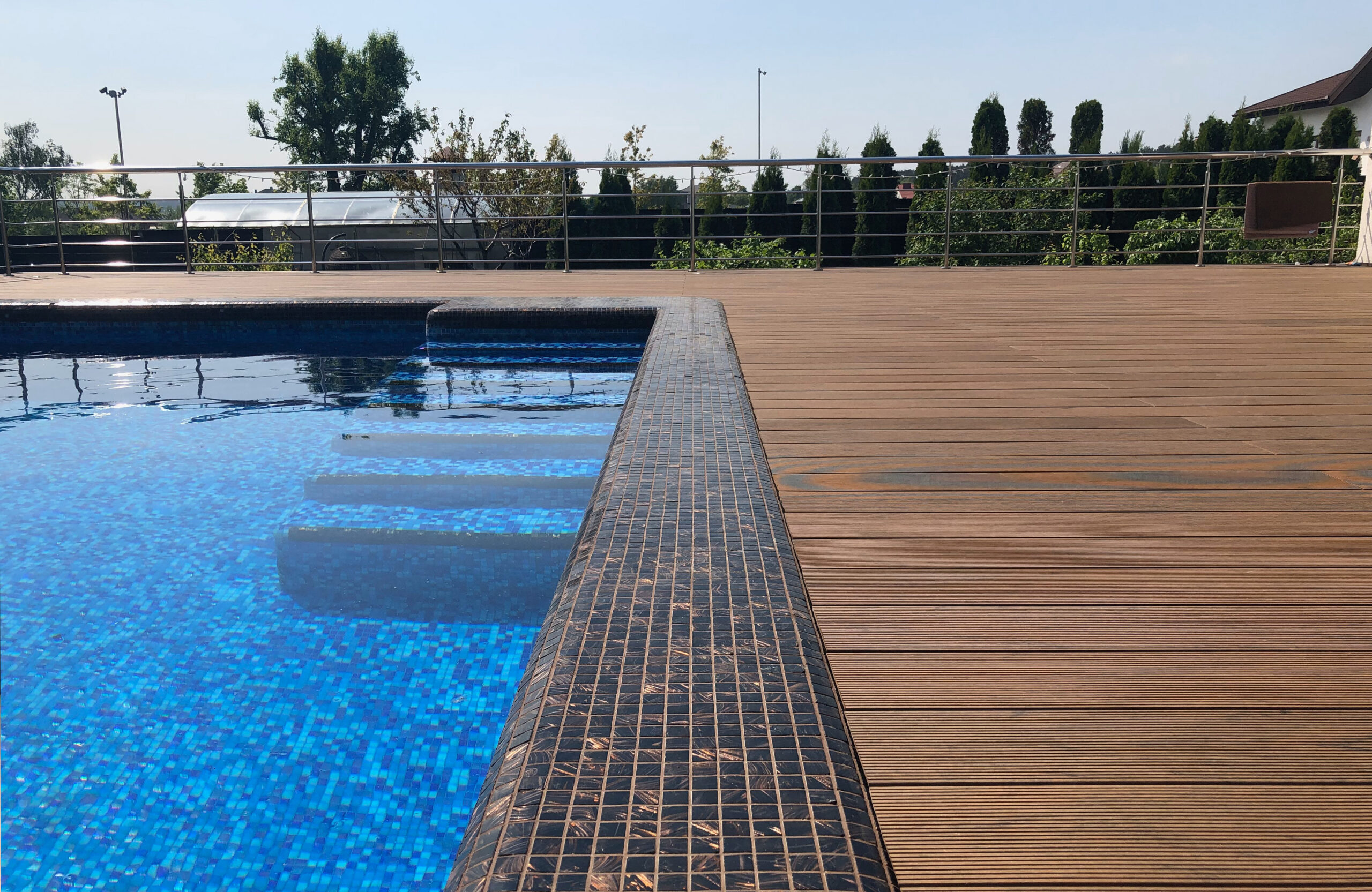 Bruggan Multicolor Cedar composite decking around a private outdoor swimming pool