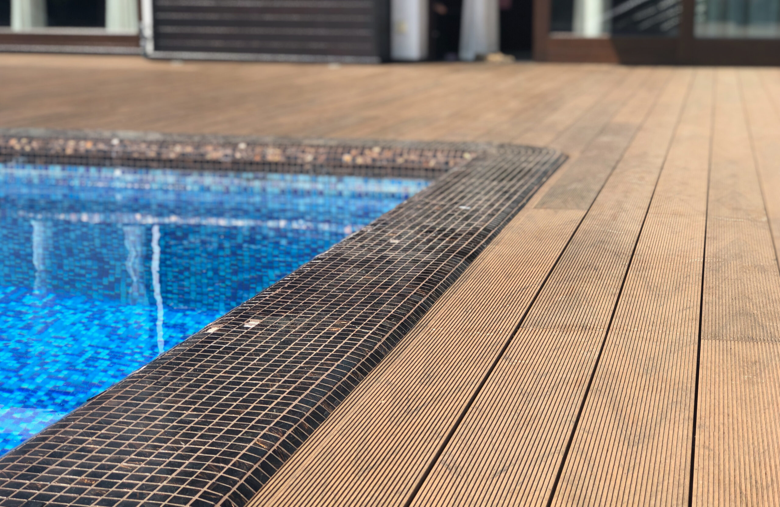 Bruggan Multicolor Cedar composite decking around a private outdoor swimming pool
