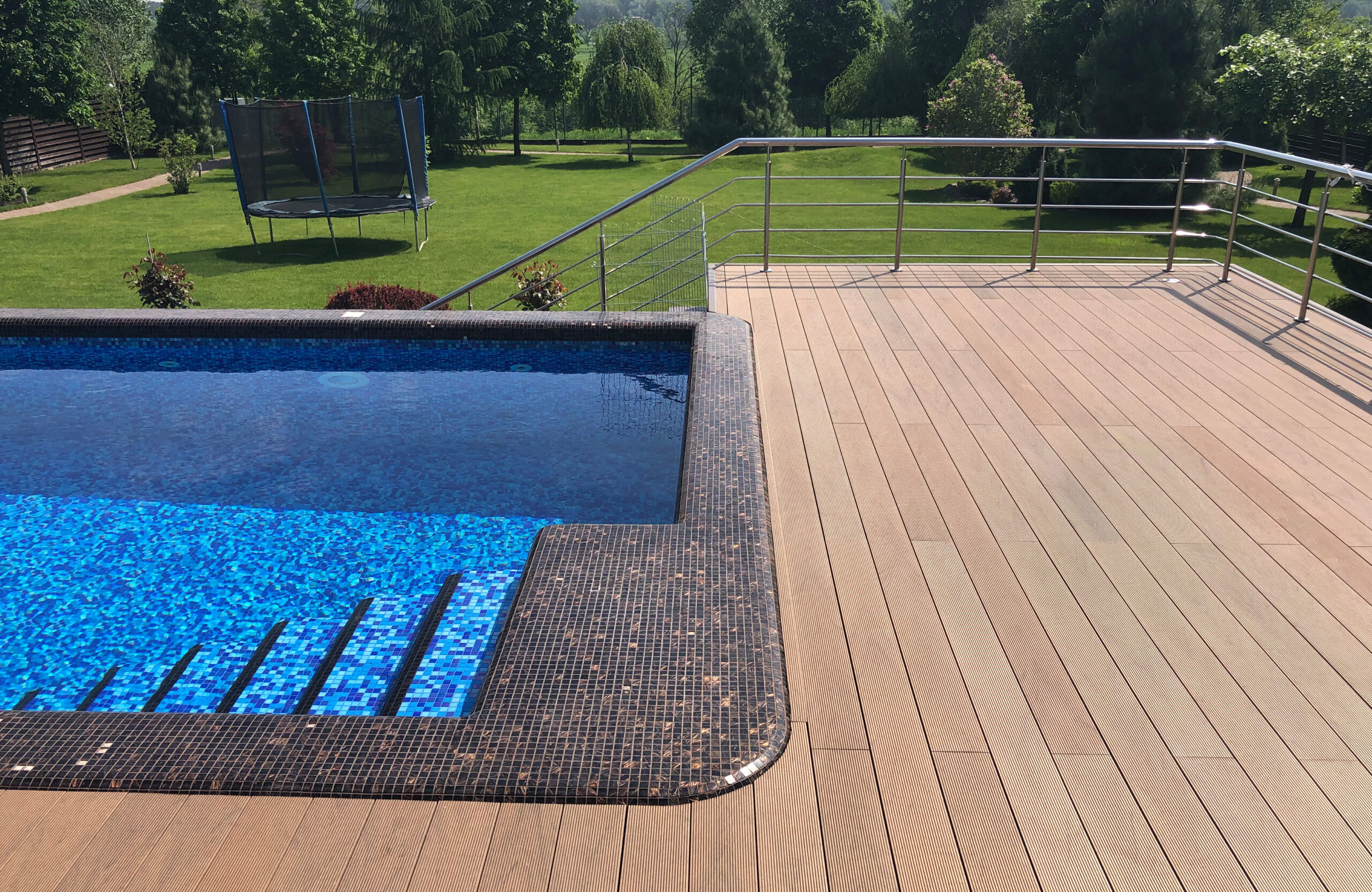 Bruggan Multicolor Cedar composite decking around a private outdoor swimming pool