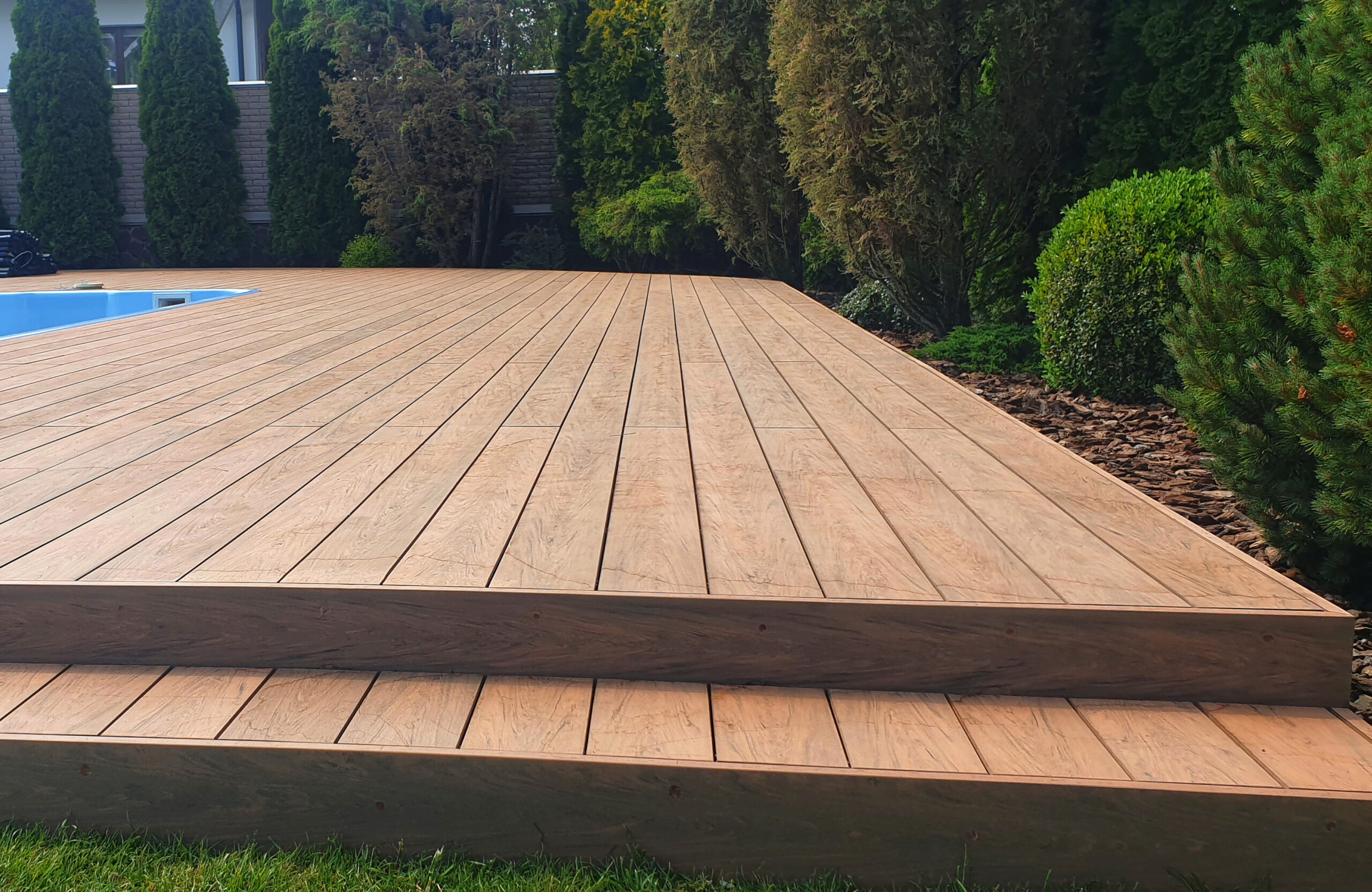 Close-up of Bruggan Multicolor Cedar decking with steps beside a swimming pool