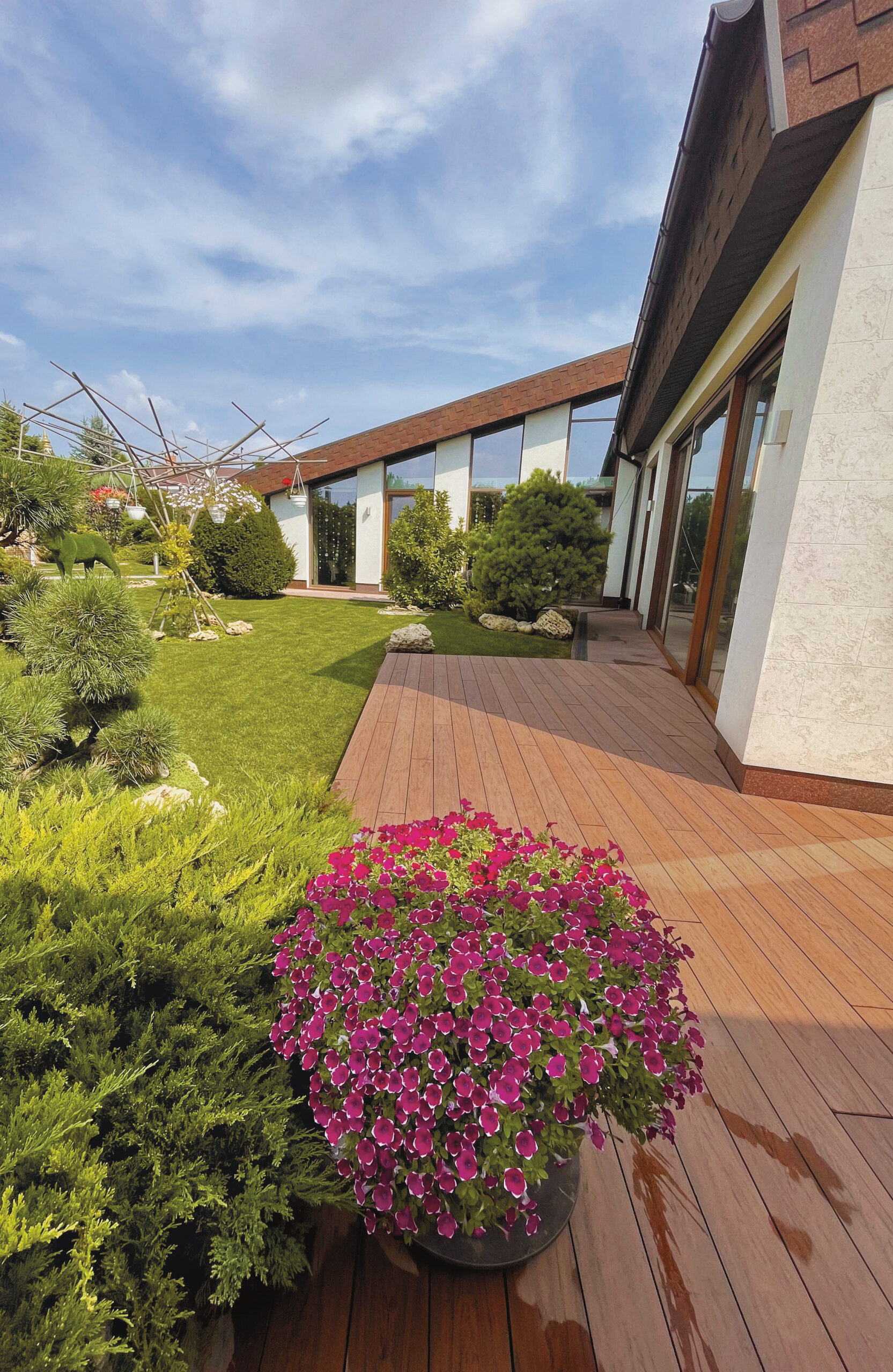 Bruggan Multicolor Cedar terrace decking beside a modern house and landscaped garden