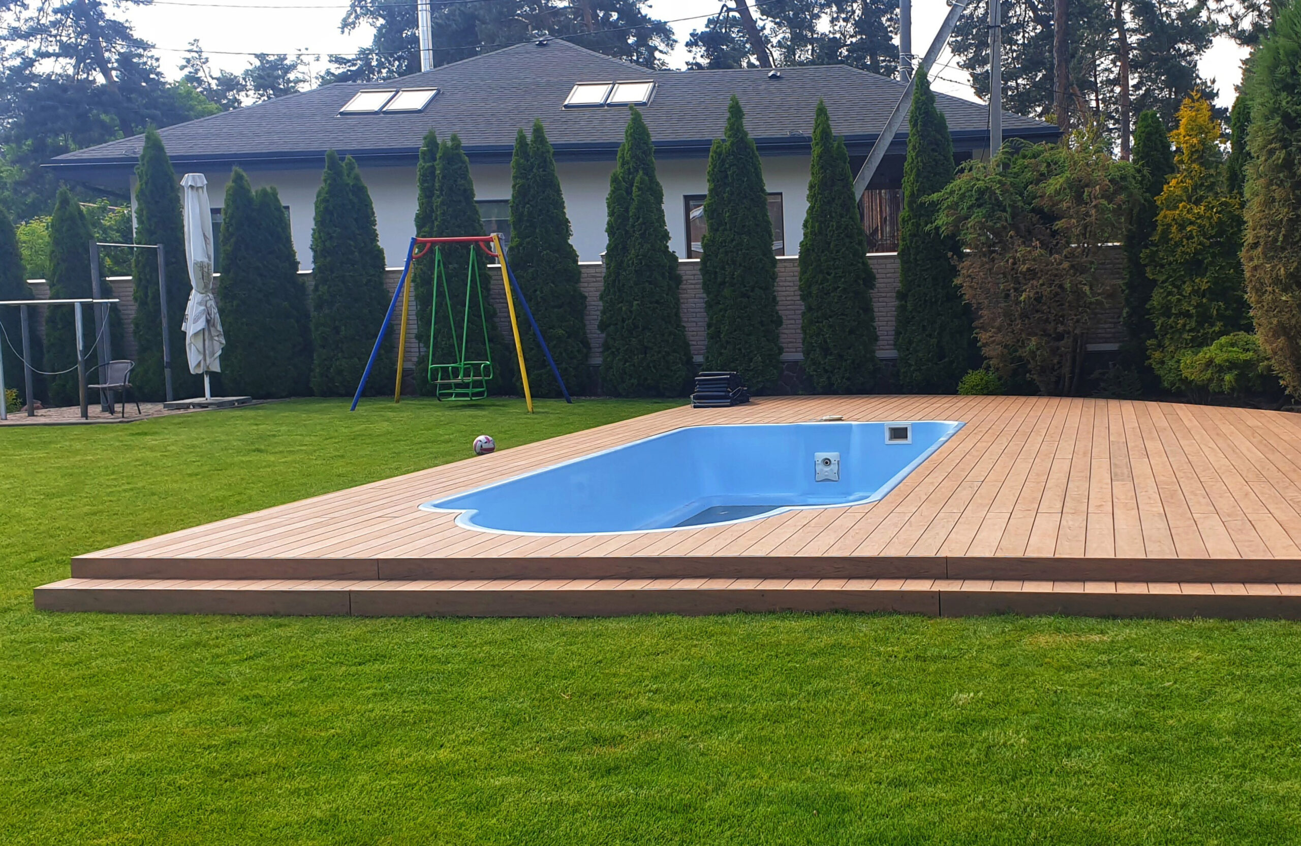 Backyard swimming pool surrounded by Bruggan Multicolor Cedar composite decking