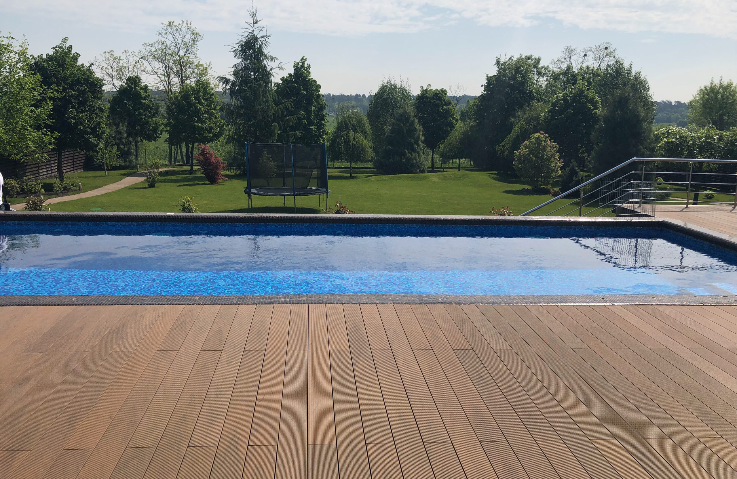 Bruggan Multicolor Cedar composite decking around a private outdoor swimming pool