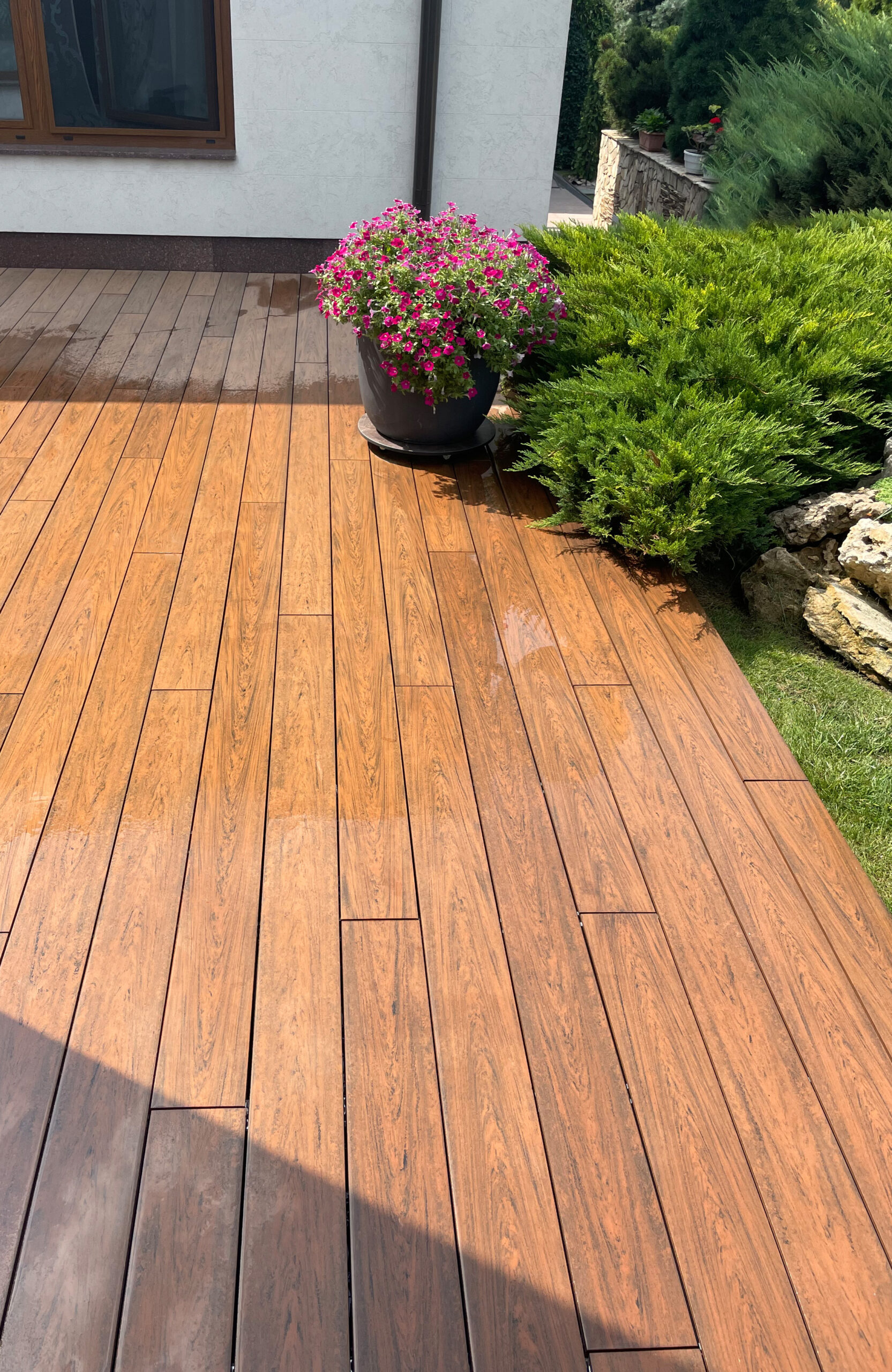 Bruggan Multicolor Cedar composite decking walkway through a landscaped garden