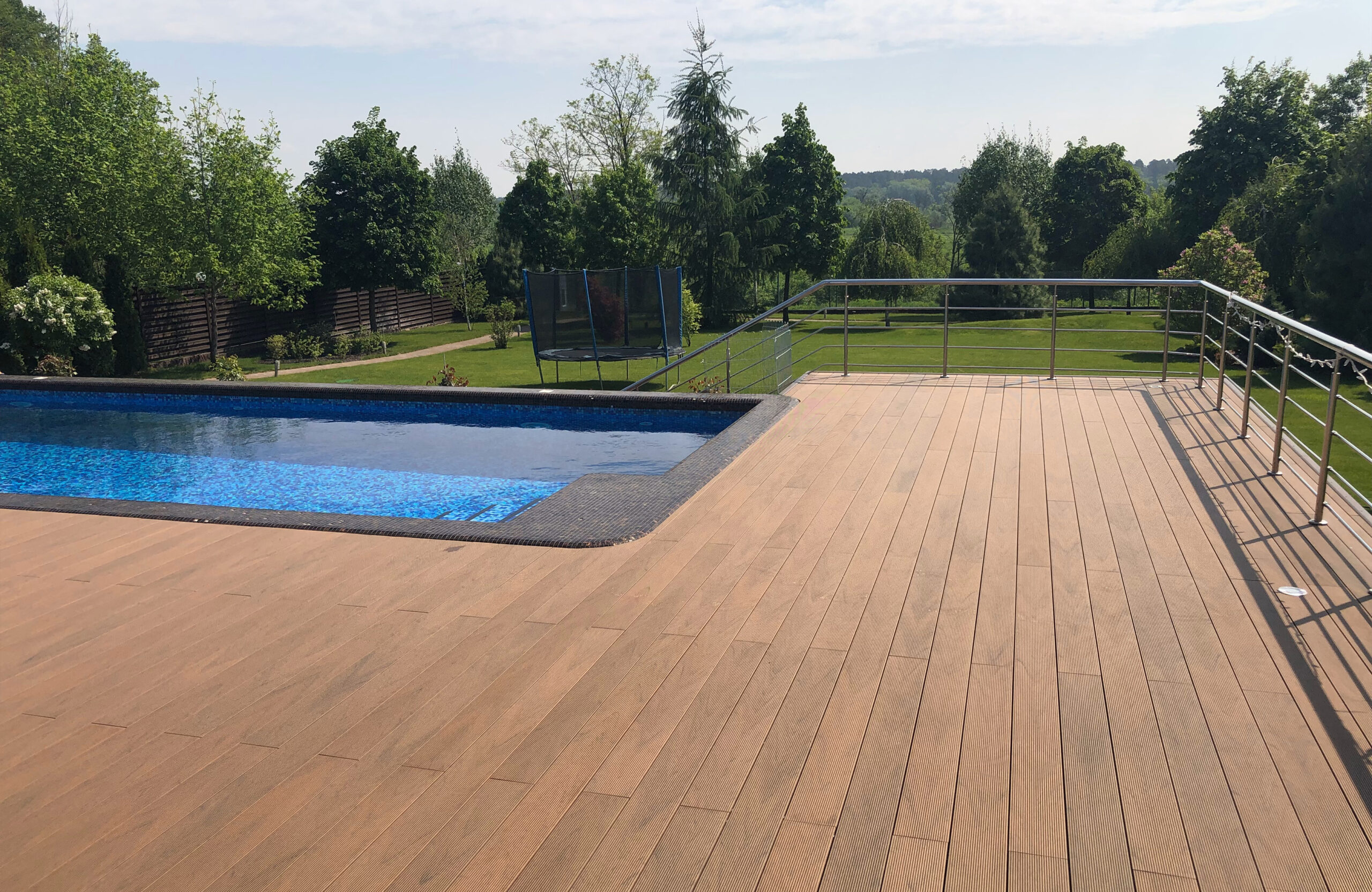 Bruggan Multicolor Cedar composite decking around a private outdoor swimming pool