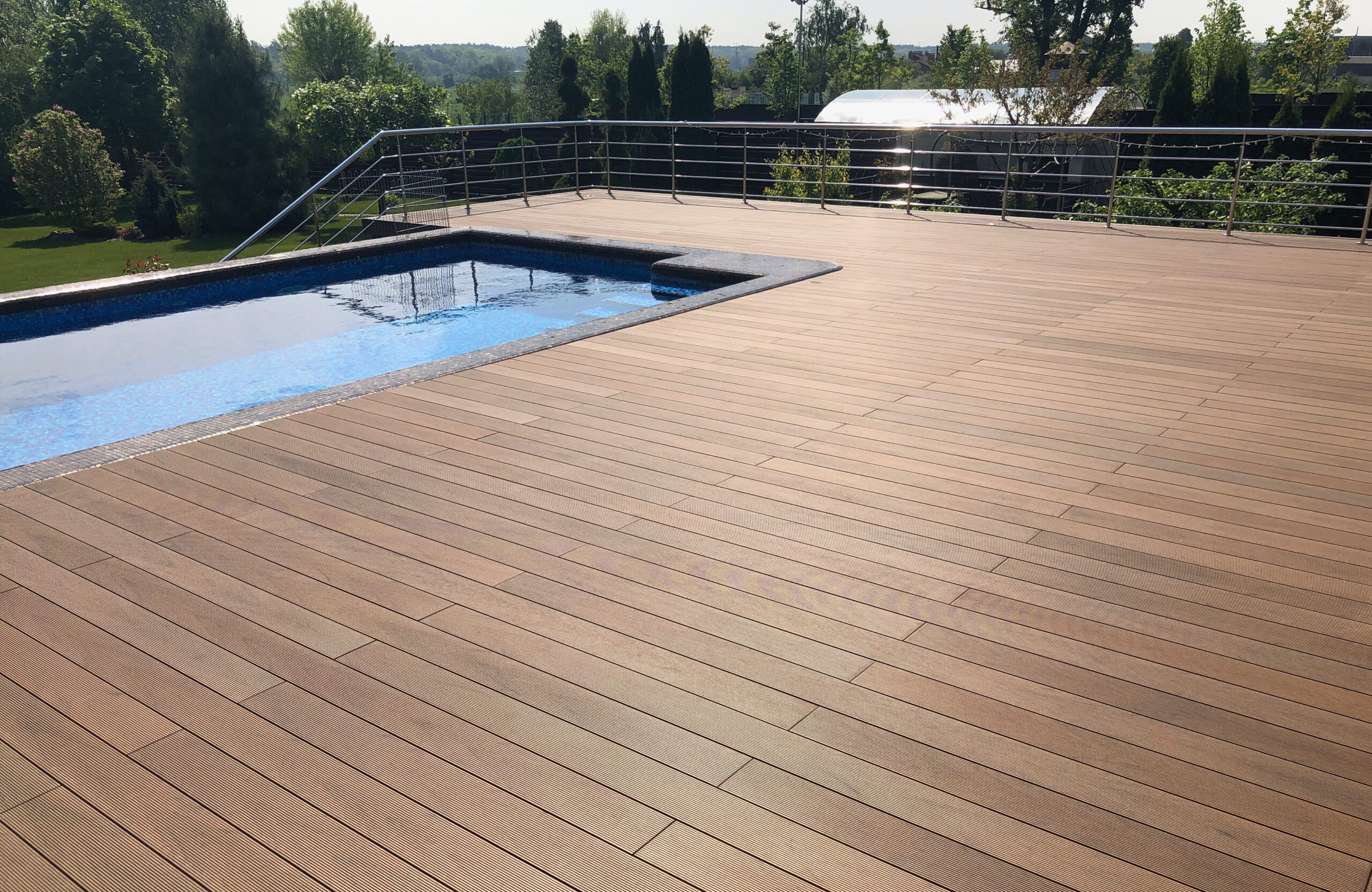 Bruggan Multicolor Cedar composite decking around a private outdoor swimming pool