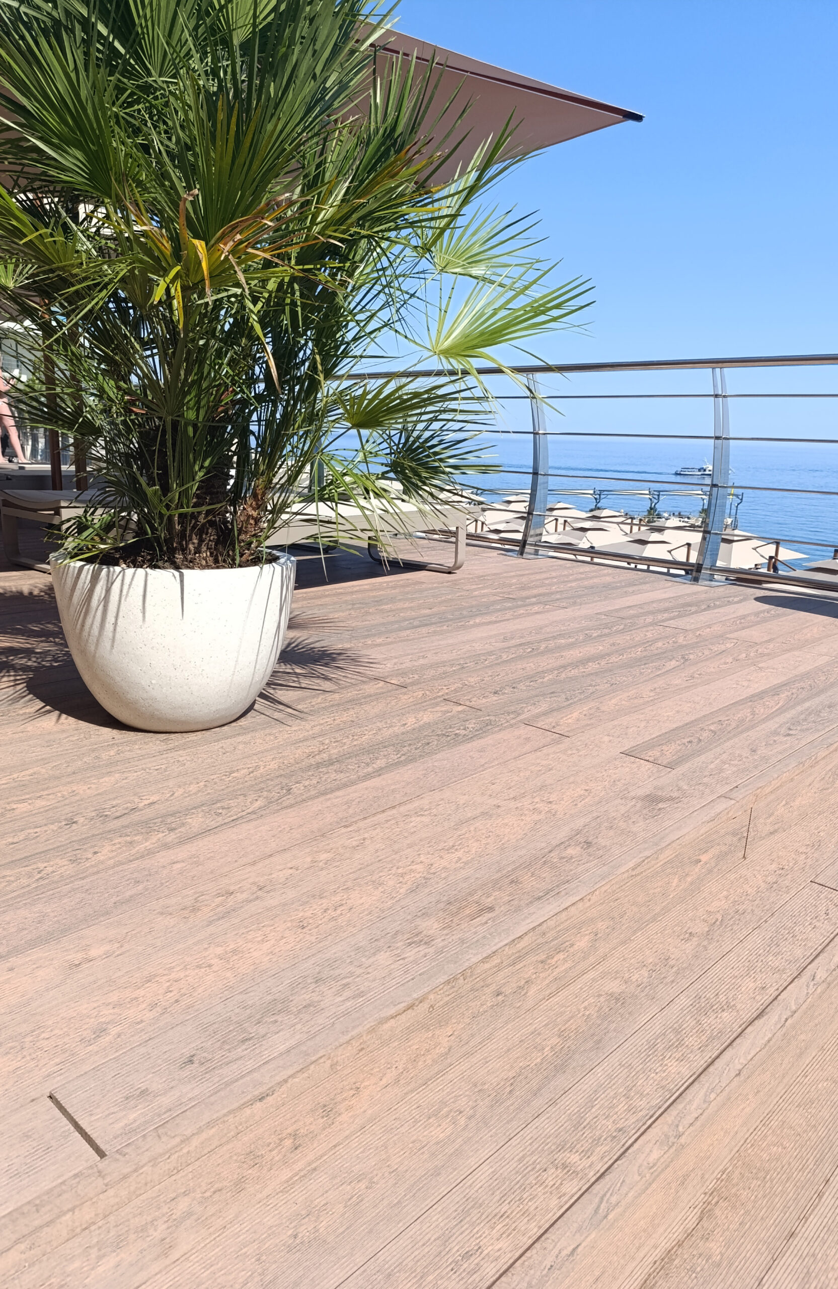 Close-up of Bruggan Multicolor Cedar composite decking on a luxury seaside terrace