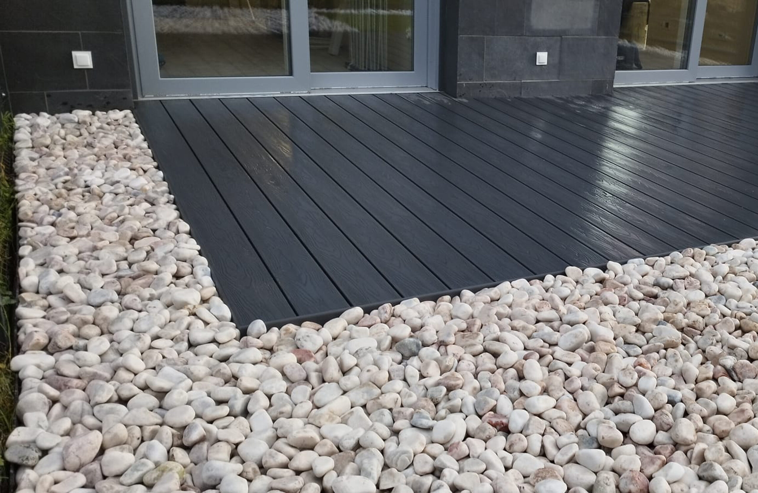 Bruggan Elegant anthracite composite decking with white decorative stones