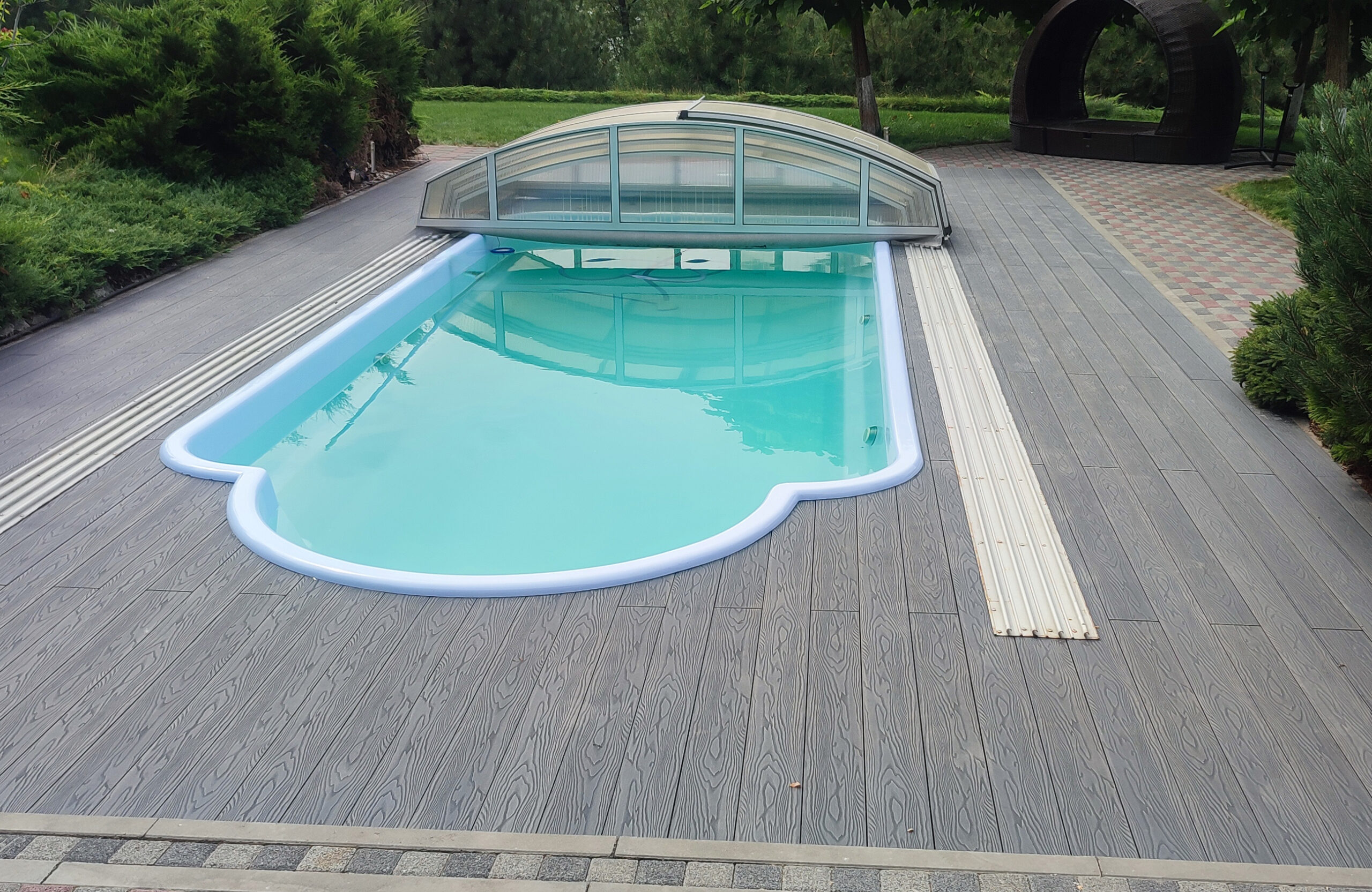Swimming pool surrounded by Bruggan Elegant Anthracite composite decking