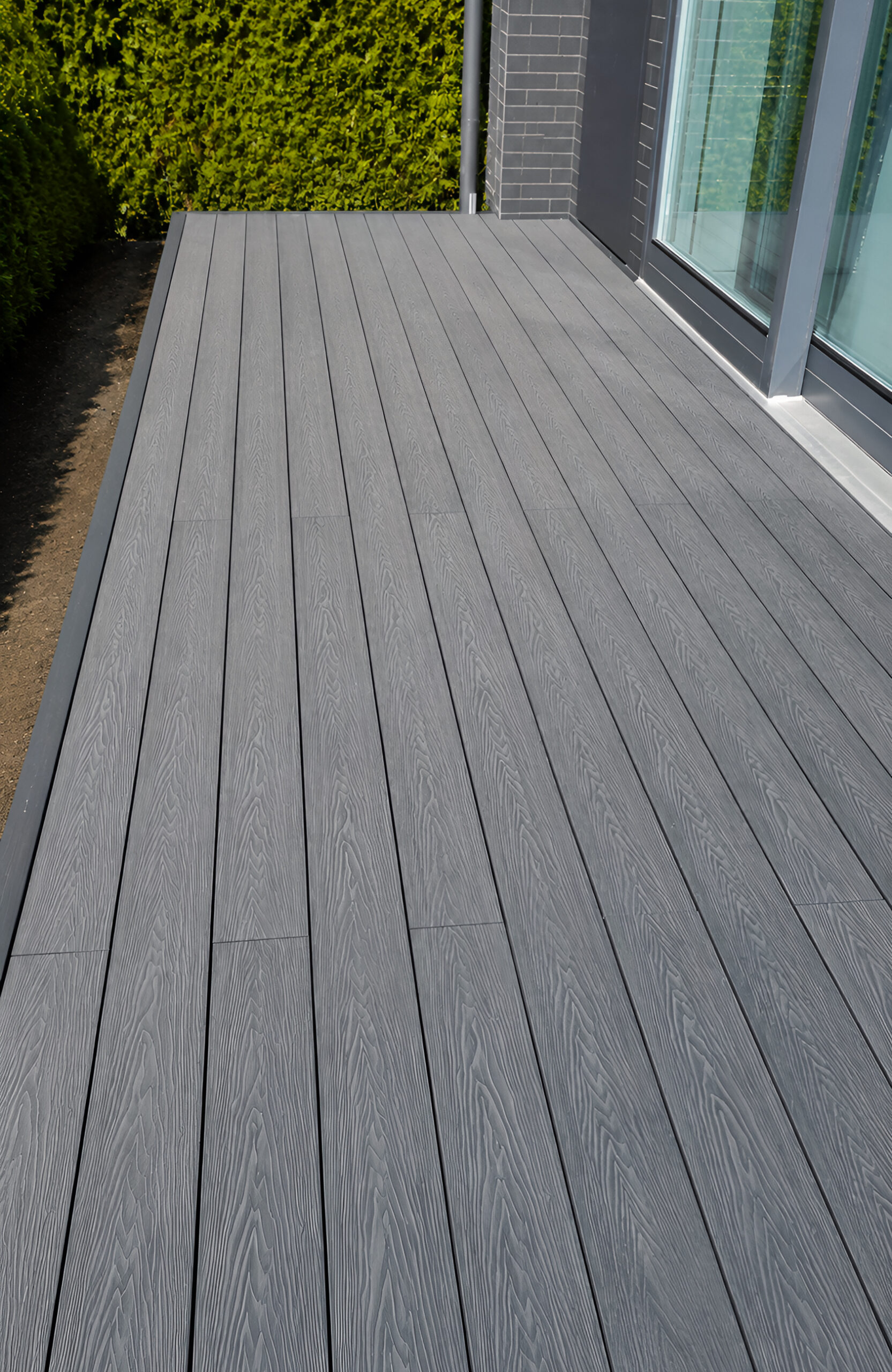 Bruggan Elegant Graphite composite decking on a modern terrace beside the house