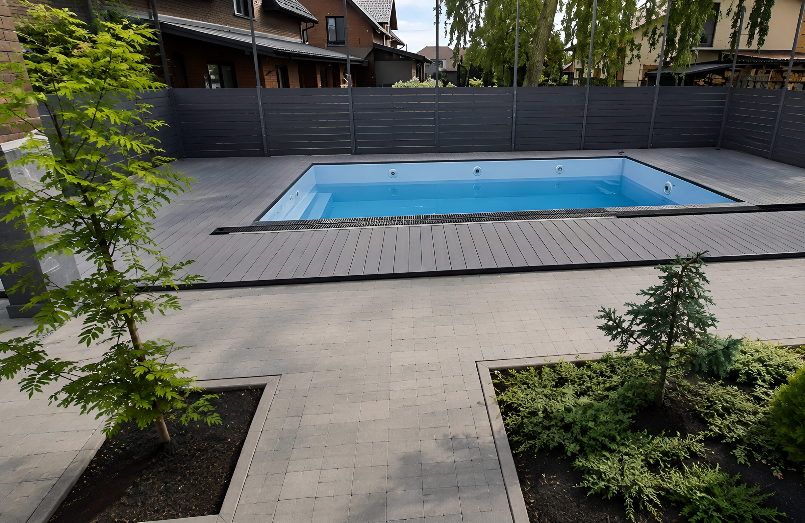 Bruggan Elegant Graphite composite decking around a modern outdoor swimming pool