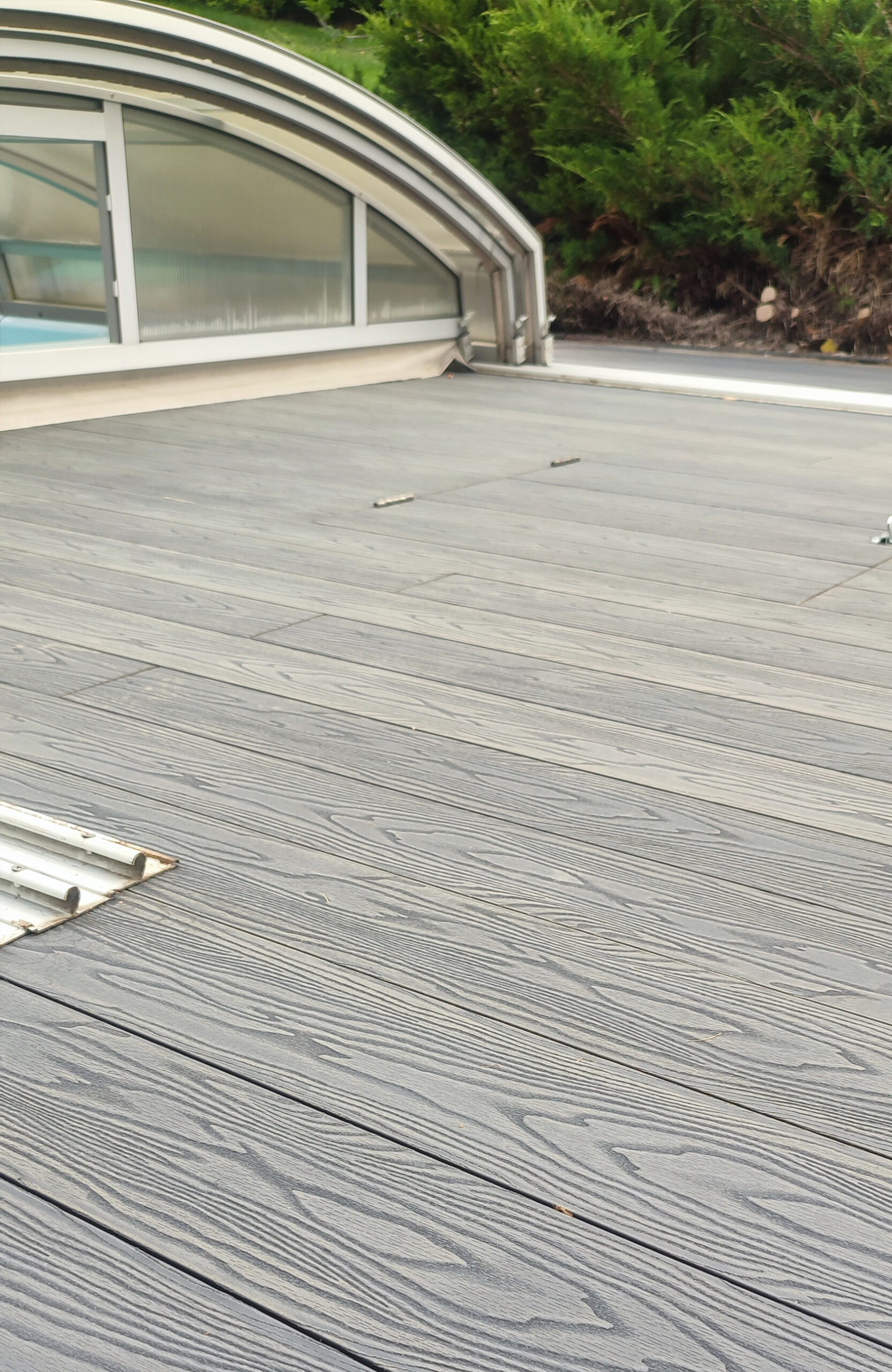 Bruggan Elegant Anthracite composite decking installed around a covered outdoor pool