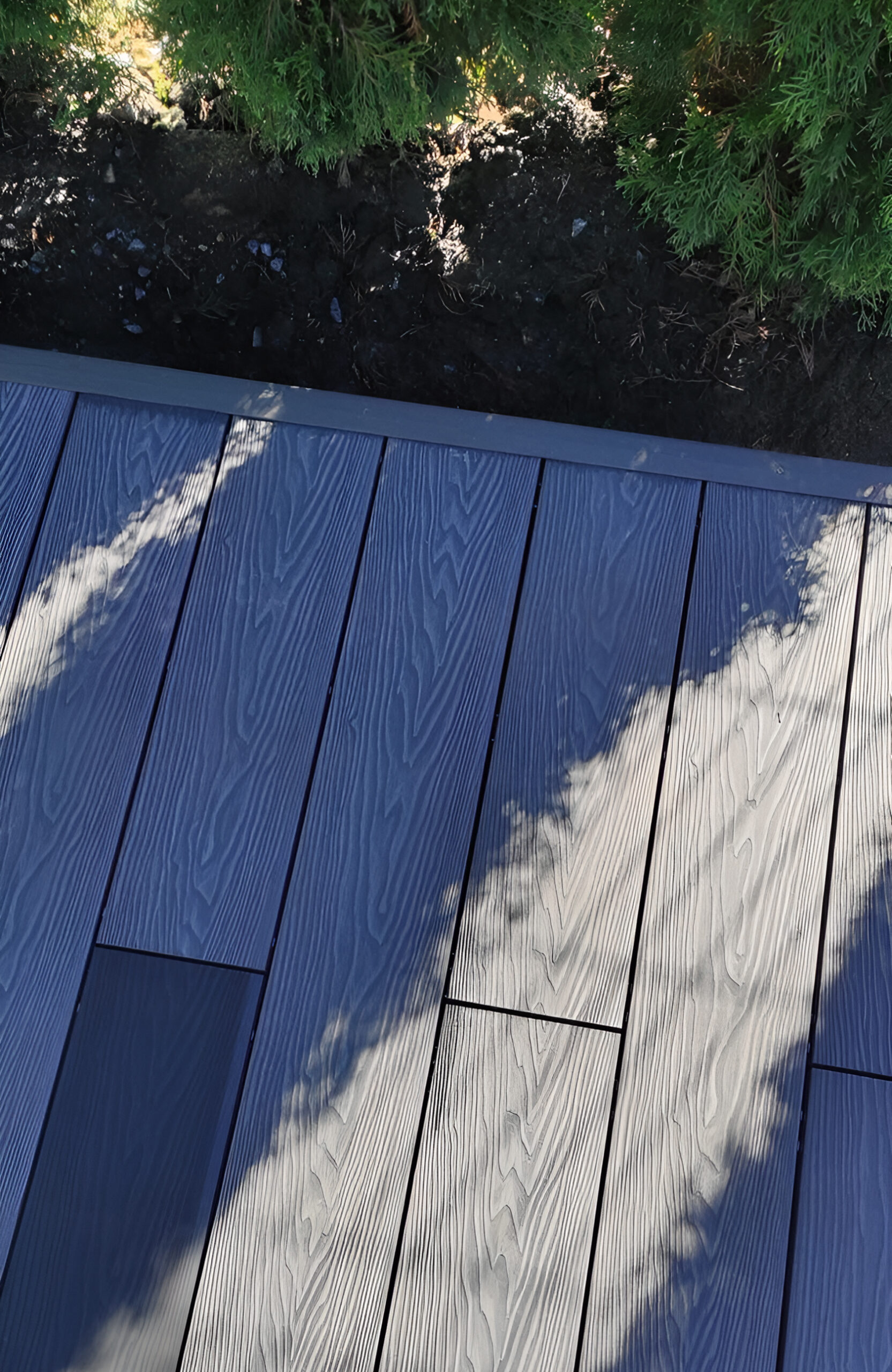 Bruggan Elegant Graphite composite deck boards with wood grain texture and natural shadows