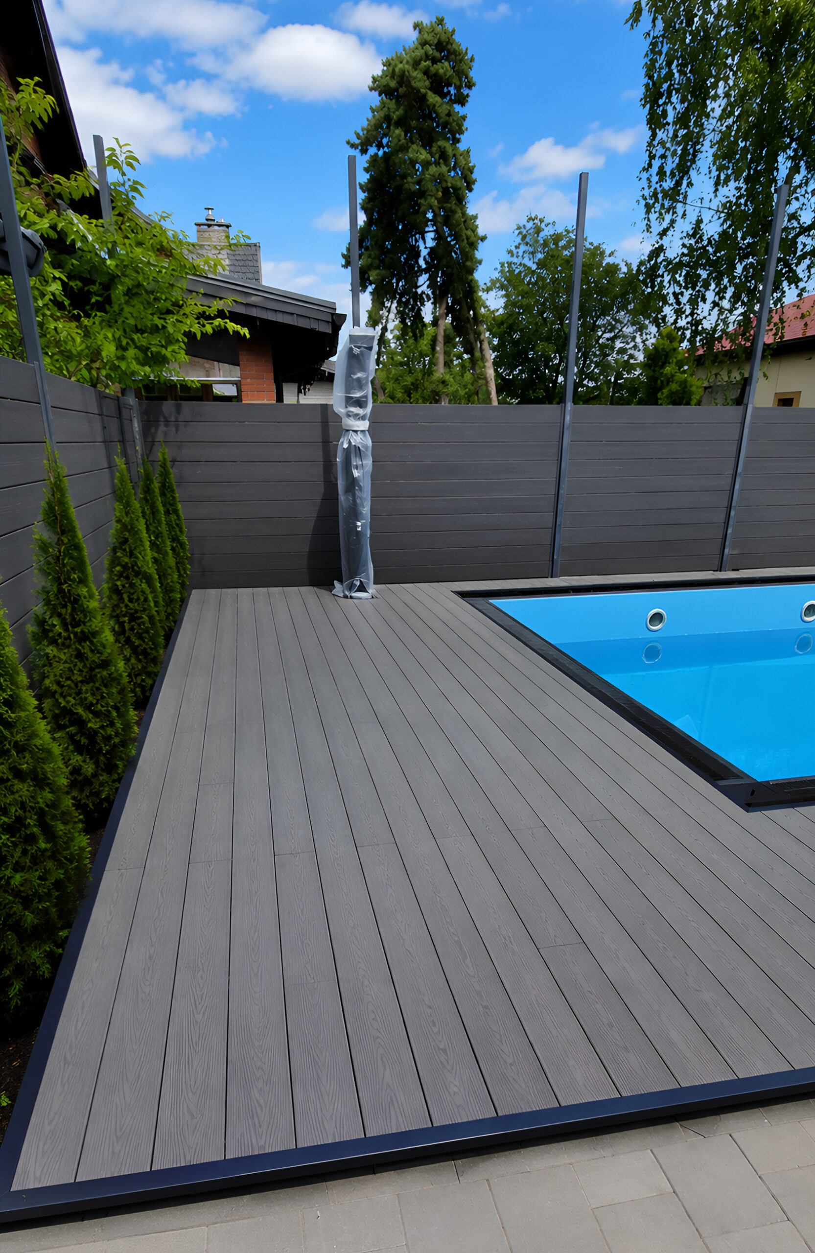 Graphite composite pool decking with Bruggan Multicolor boards and matching privacy fence