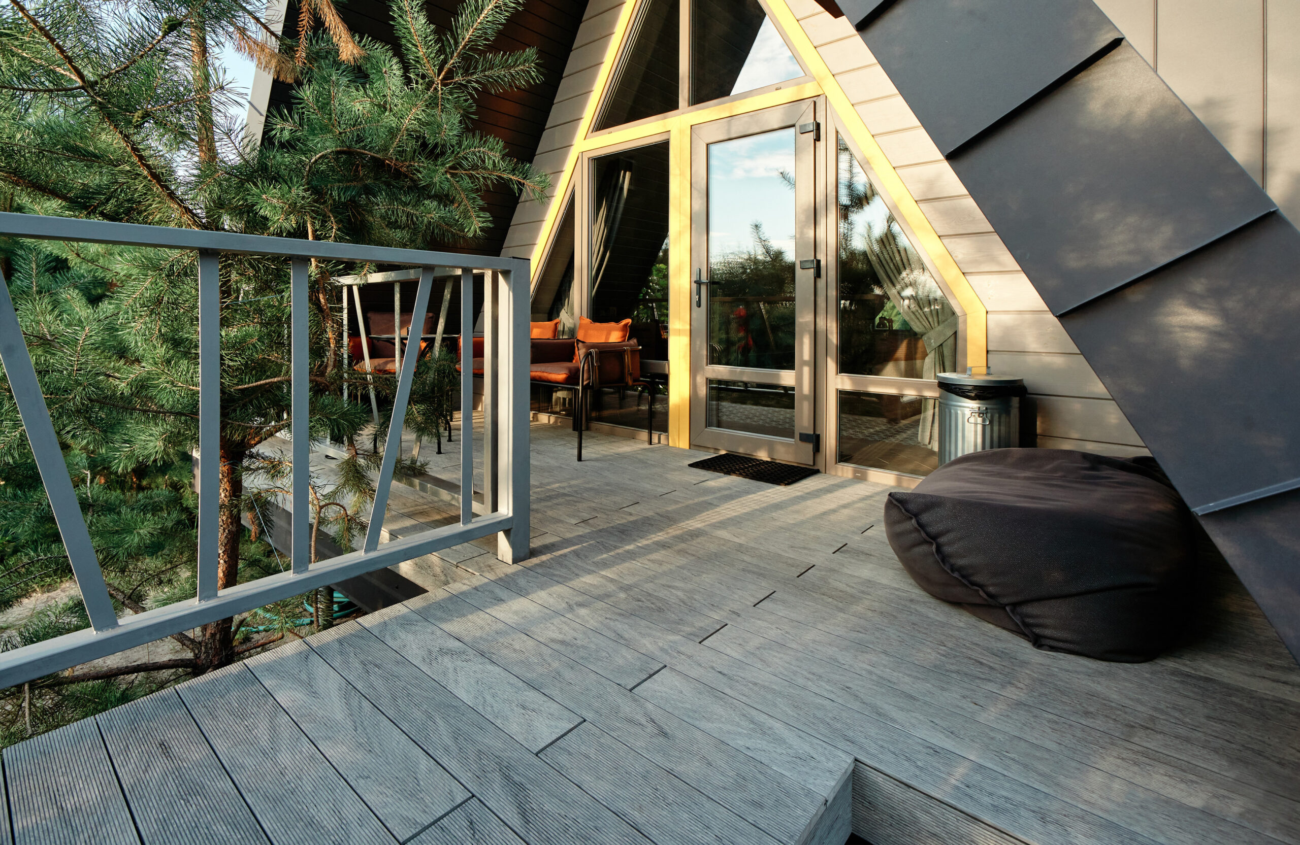 Grey BRUGGAN Multicolor composite decking on a modern outdoor terrace surrounded by pine trees