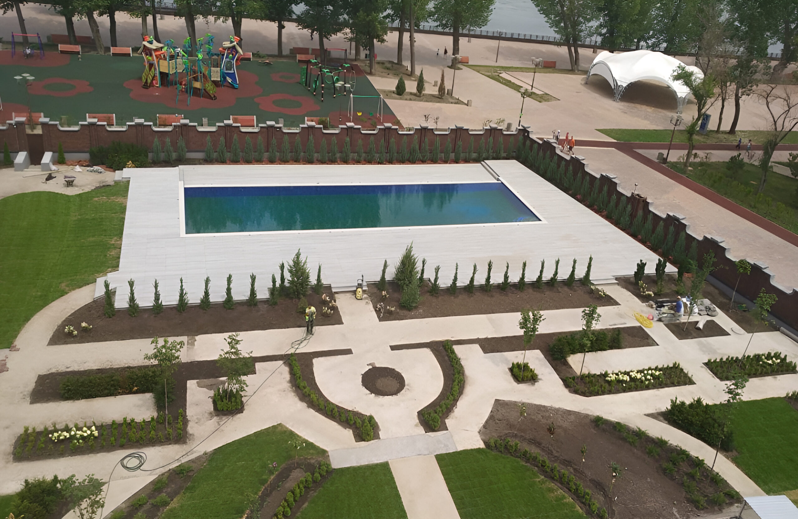 BRUGGAN Multicolor grey composite decking installed around a large outdoor swimming pool
