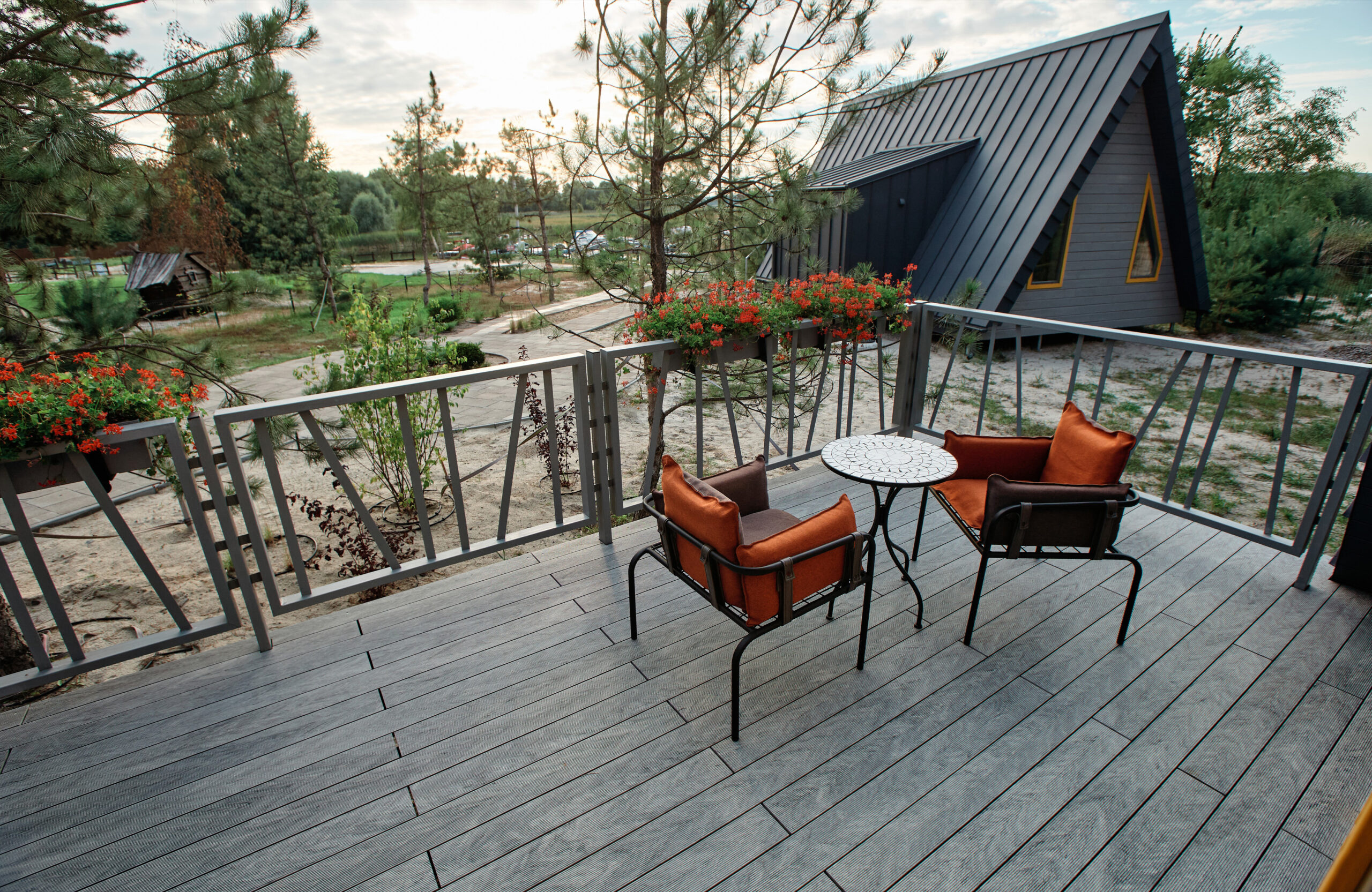 Grey BRUGGAN Multicolor composite decking on a modern outdoor terrace surrounded by pine trees