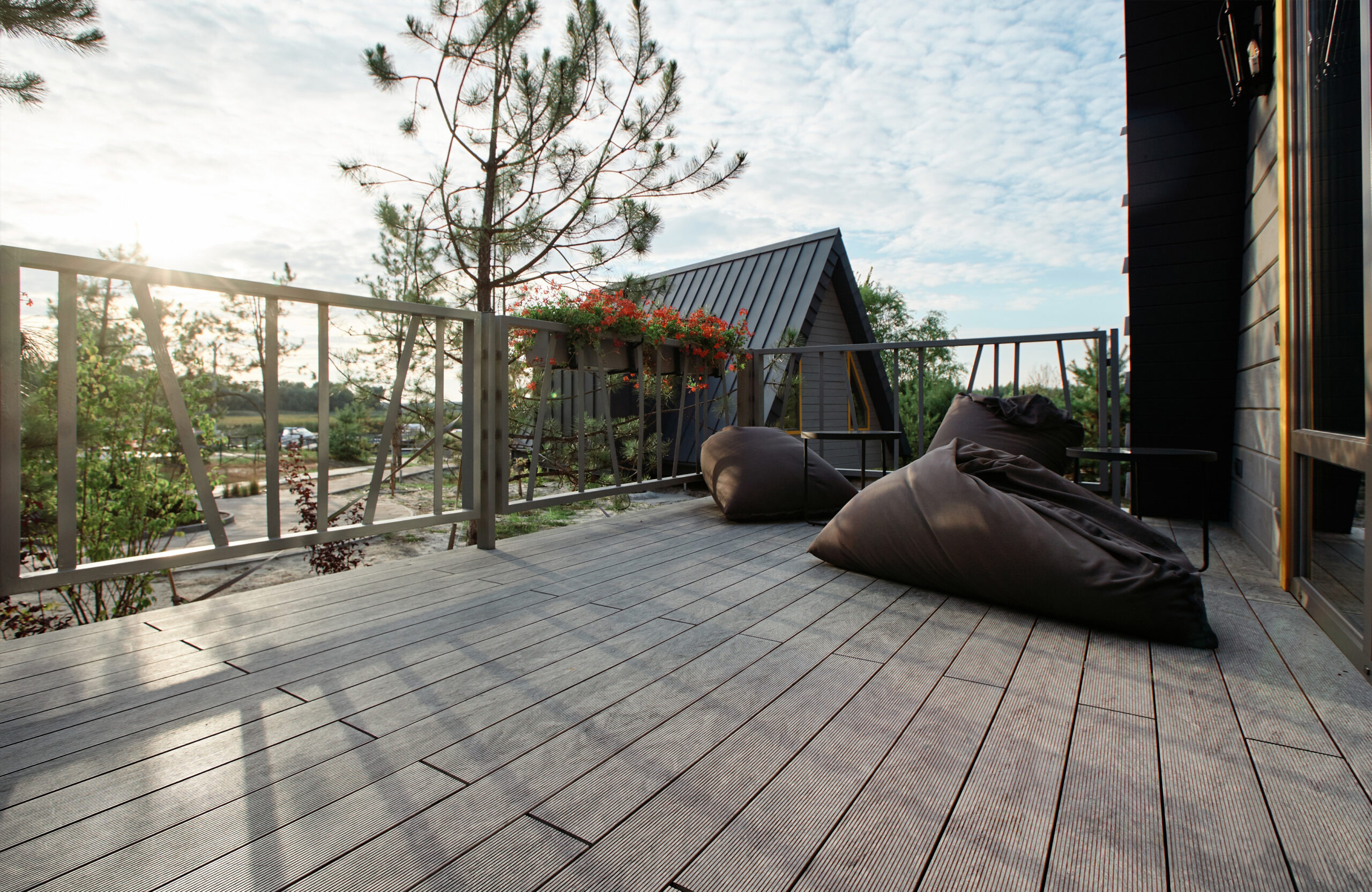 Grey BRUGGAN Multicolor composite decking on a modern outdoor terrace surrounded by pine trees