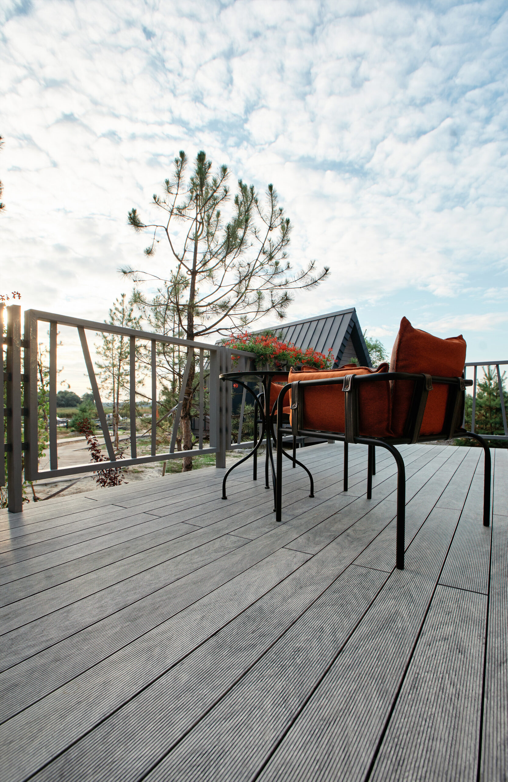 Grey BRUGGAN Multicolor composite decking on a modern outdoor terrace surrounded by pine trees