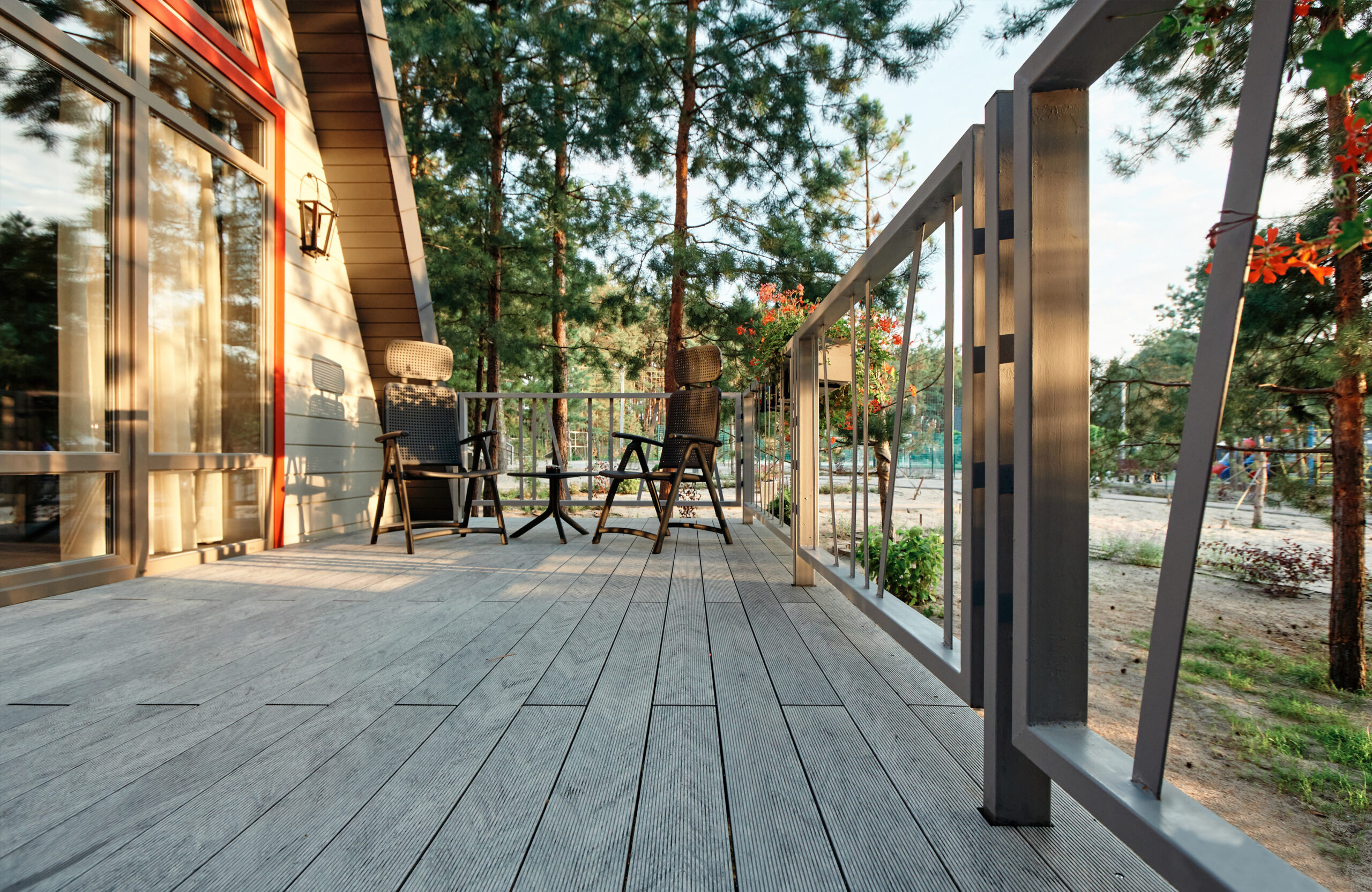 Grey BRUGGAN Multicolor composite decking on a modern outdoor terrace surrounded by pine trees