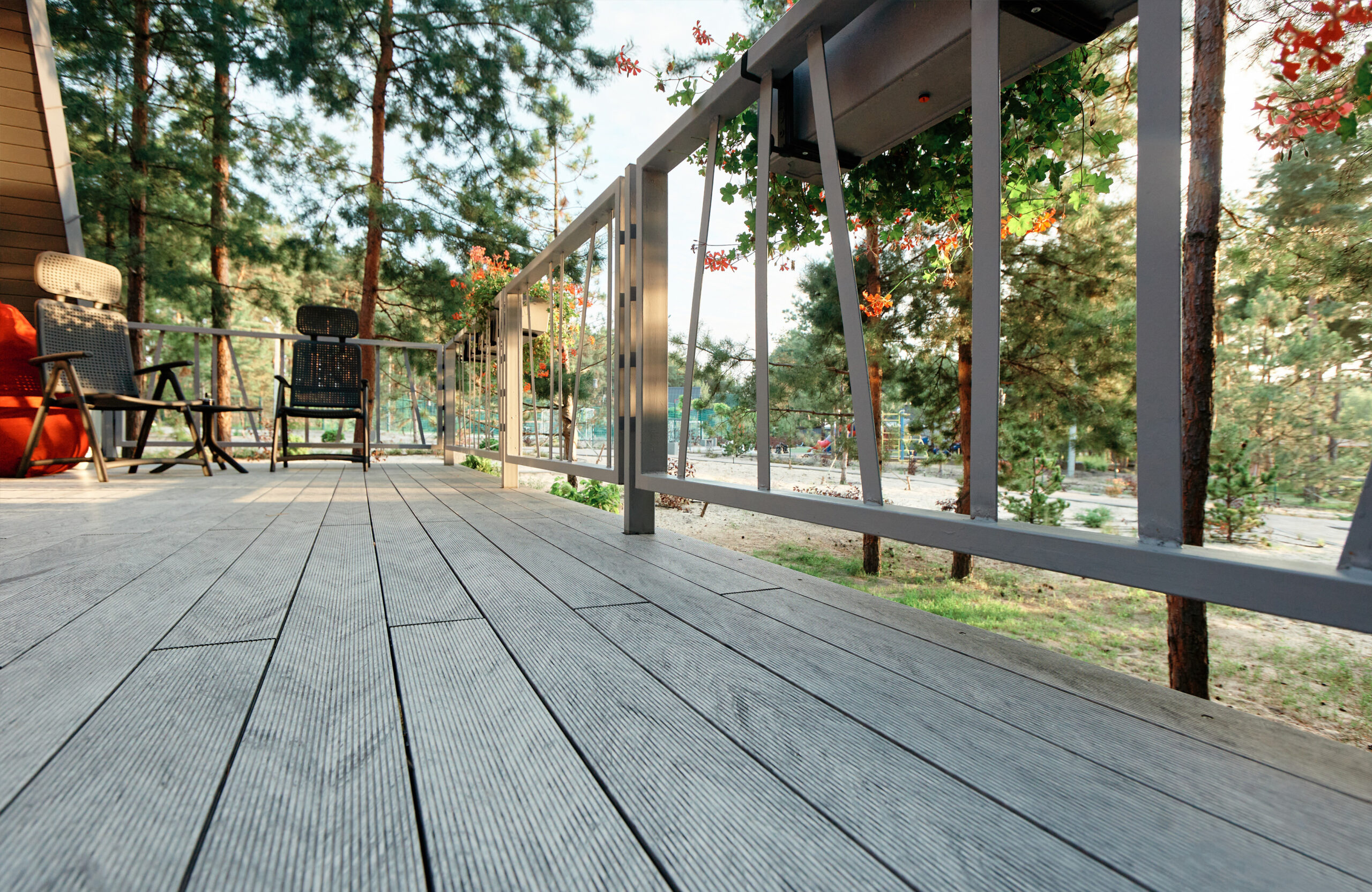 Grey BRUGGAN Multicolor composite decking on a modern outdoor terrace surrounded by pine trees