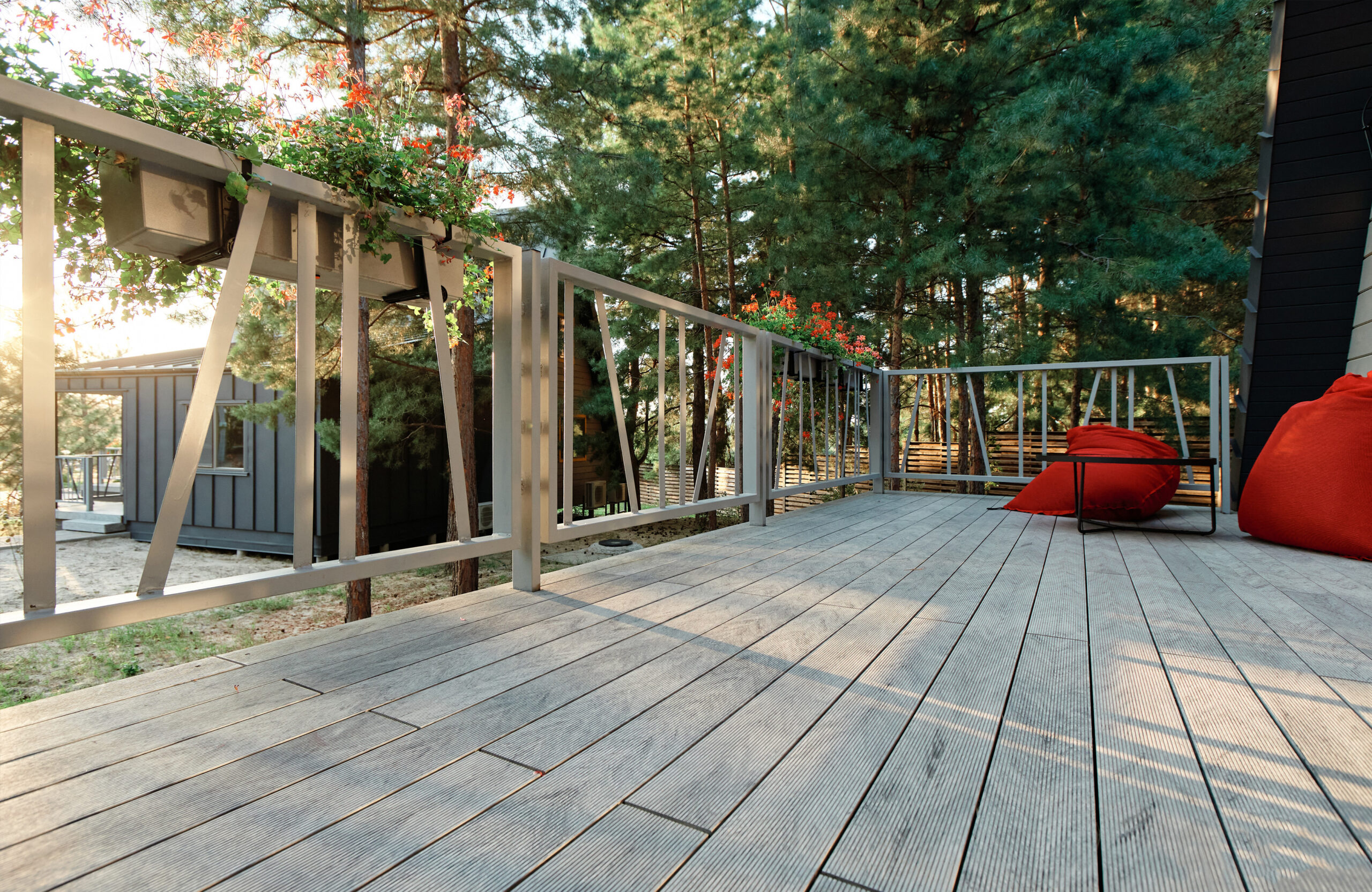 Grey BRUGGAN Multicolor composite decking on a modern outdoor terrace surrounded by pine trees