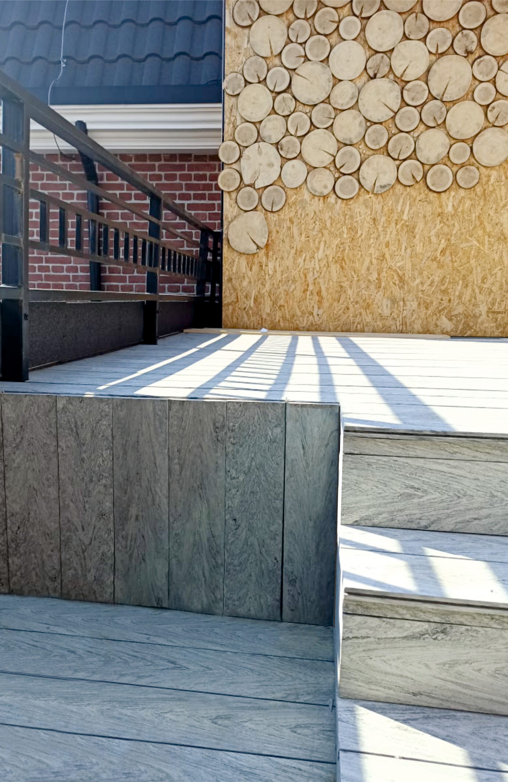 BRUGGAN Multicolor grey composite decking used for an outdoor terrace, steps and built-in bench