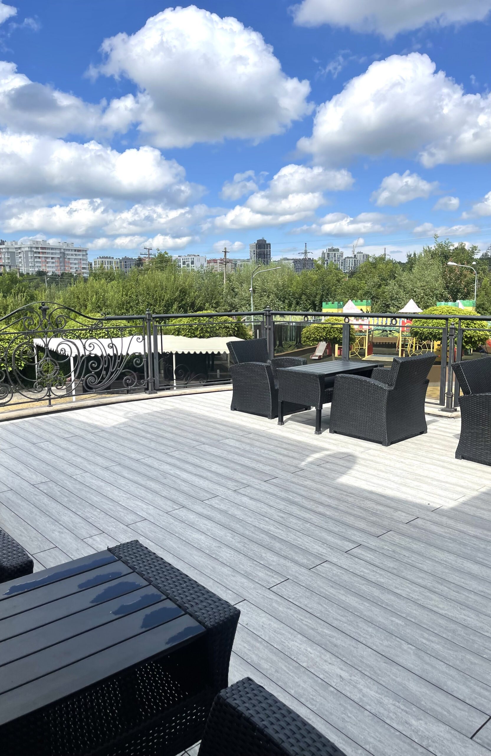 BRUGGAN MultiColor Grey composite decking on an outdoor restaurant terrace with panoramic city views