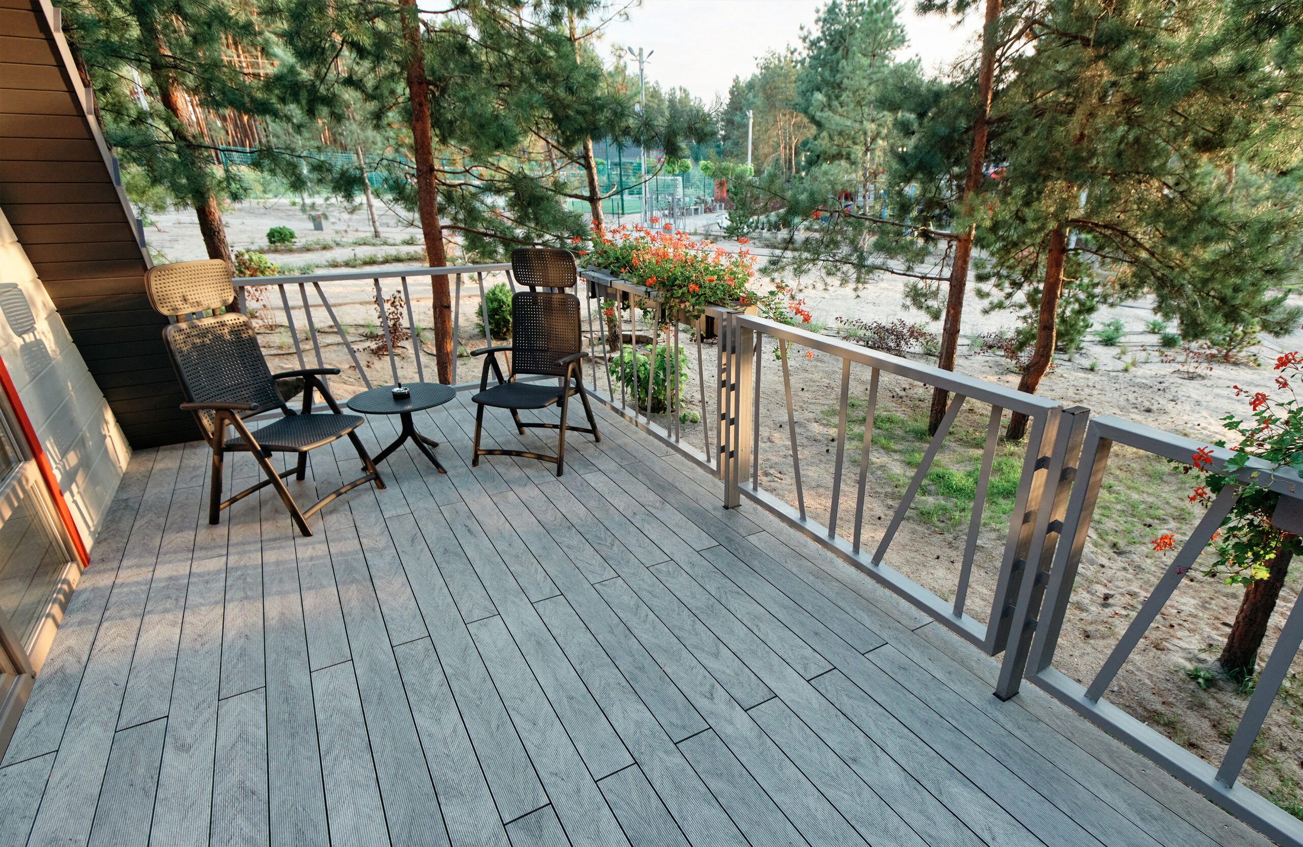 Grey BRUGGAN Multicolor composite decking on a modern outdoor terrace surrounded by pine trees