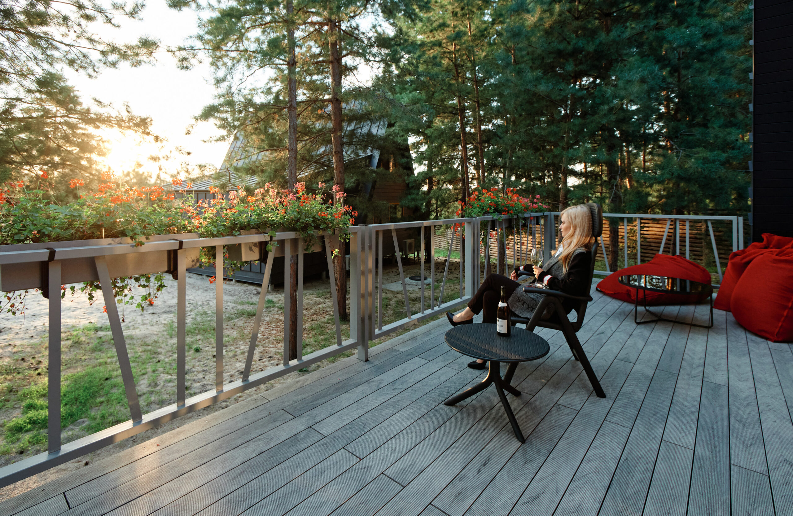 Grey BRUGGAN Multicolor composite decking on a modern outdoor terrace surrounded by pine trees