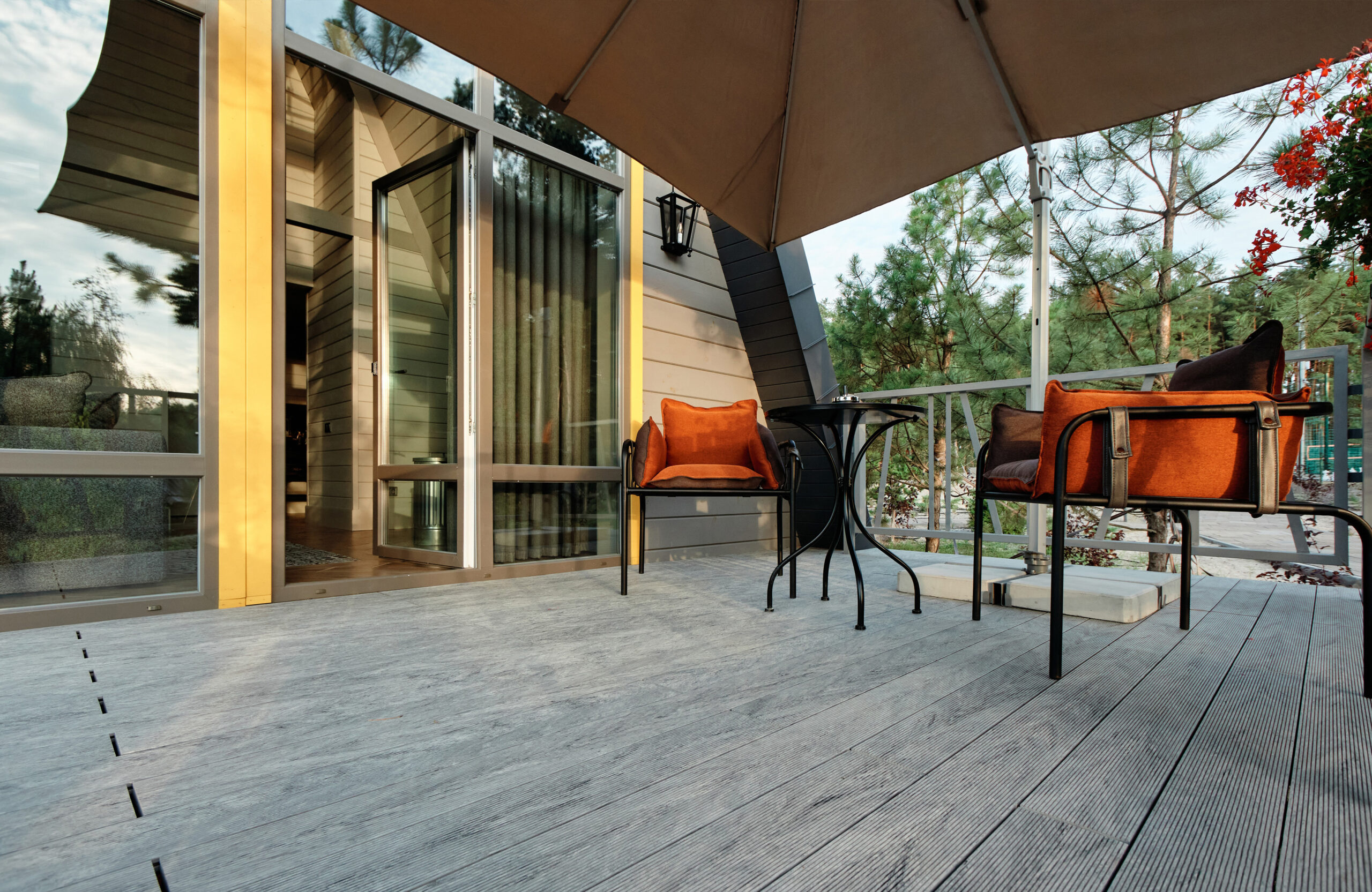 Grey BRUGGAN Multicolor composite decking on a modern outdoor terrace surrounded by pine trees